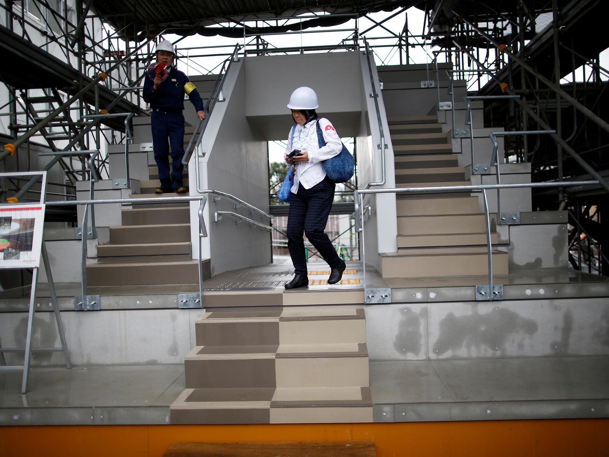 A woman works at the New National Stadium, the main arena of the Tokyo 2020 Olympics and Paralympics