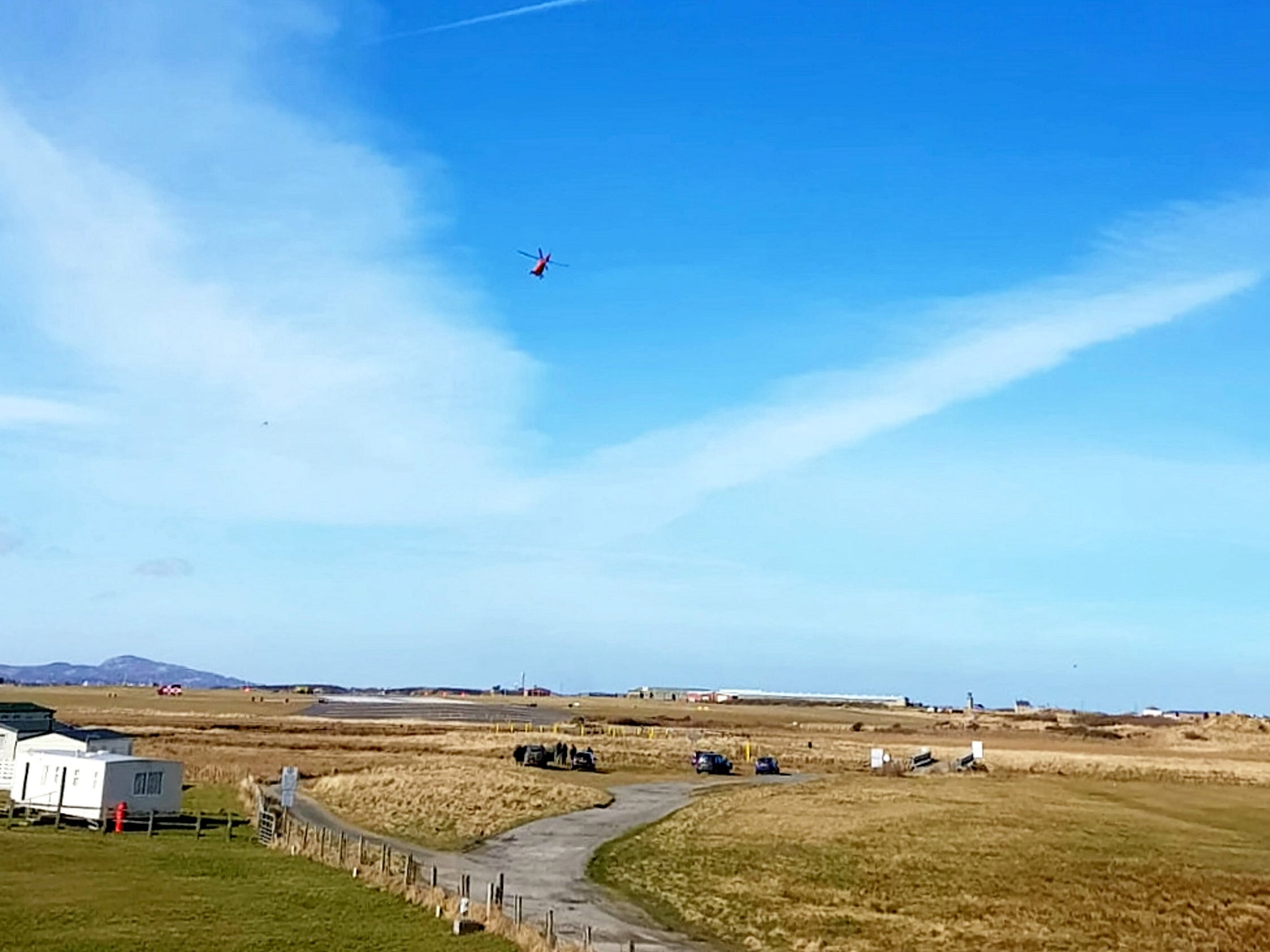 A helicopter is seen at RAF Valley after a Red Arrows Hawk jet crashed