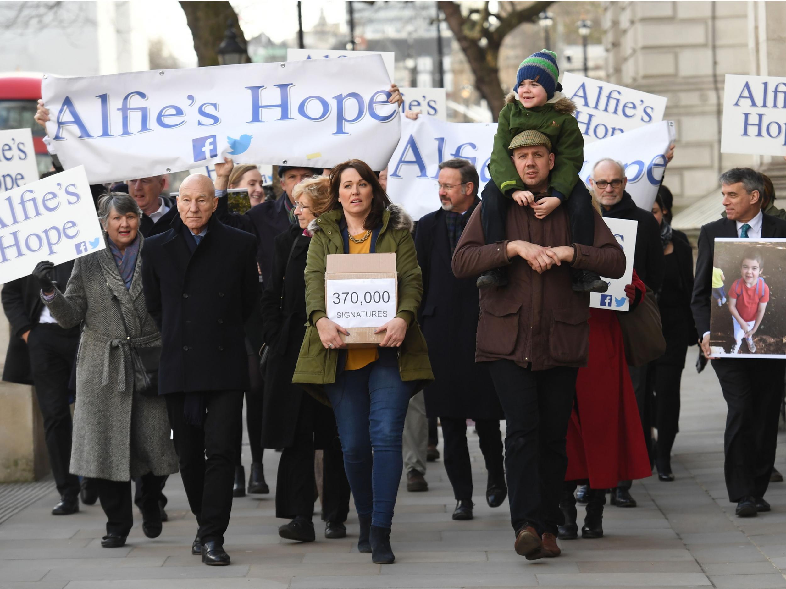 Six-year-old Alfie, his parents Drew Dingley and Hannah Deacon and actor Sir Patrick Stewart (left) walk up Whitehall