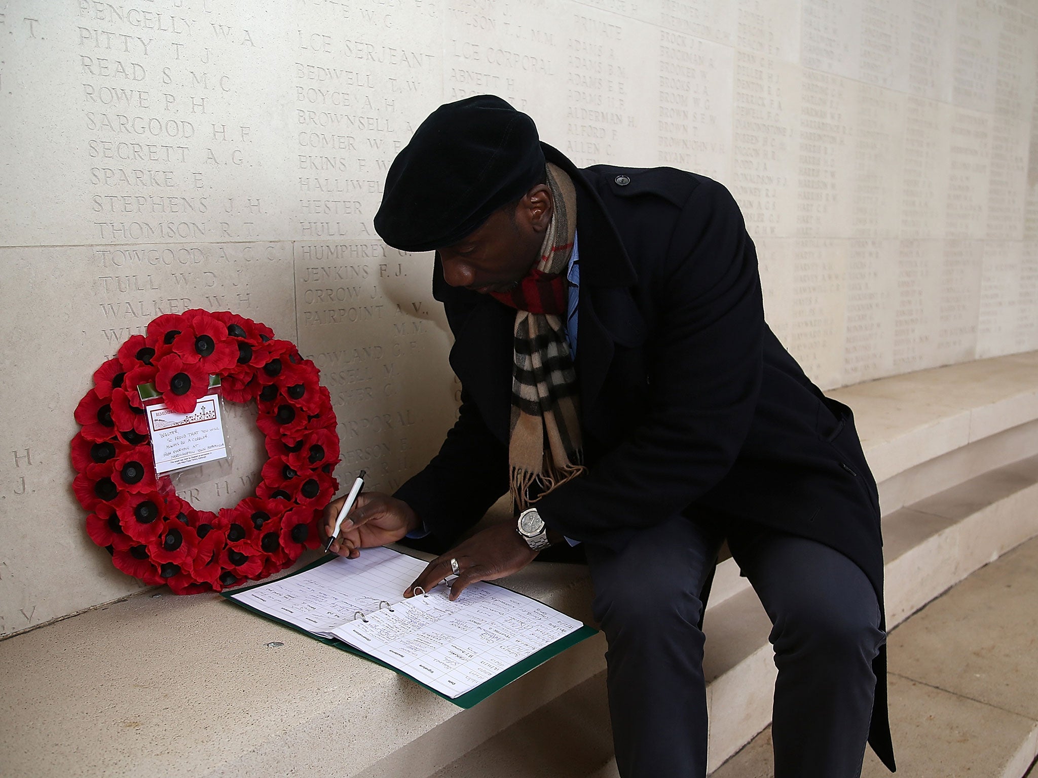 Northampton Town manager Jimmy Floyd Hasselbaink signs a visitors book at The Arras Memorial after laying a wreath to honour former Northampton Town player Walter Tull