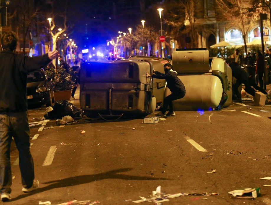 Protestors erect barricades on a street during skirmishes with police in Barcelona, Spain