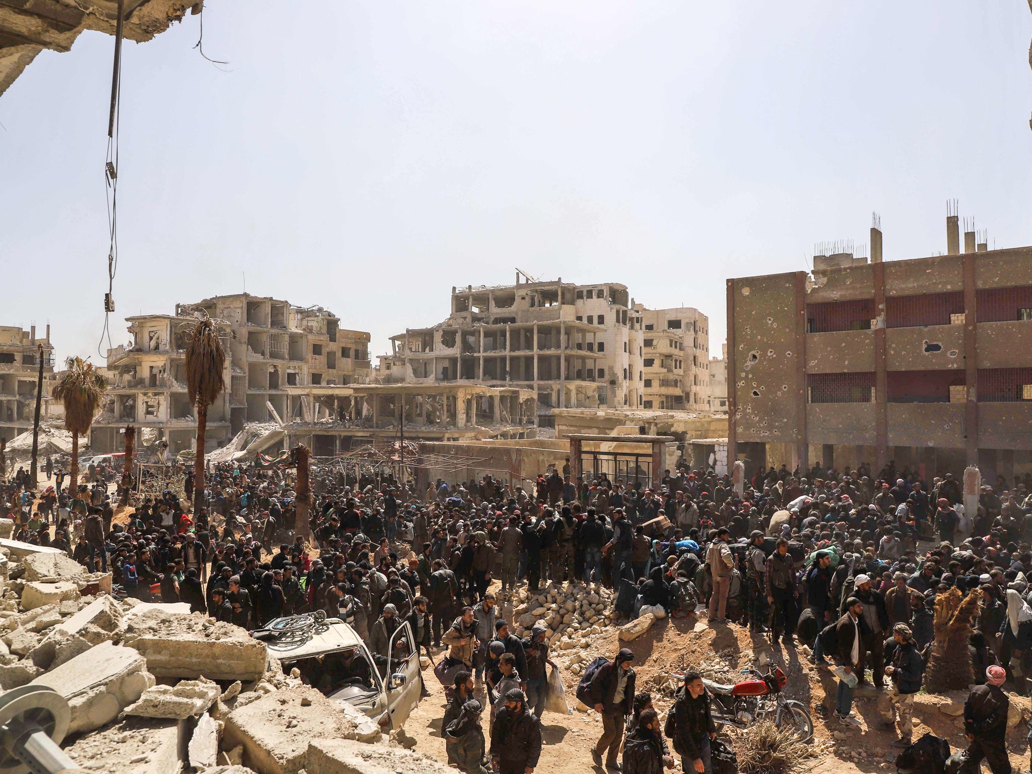 Syrian civilians gathering for their evacuation from the town of Arbin in the Eastern Ghouta region on the outskirts of the capital Damascus, following a deal with the regime