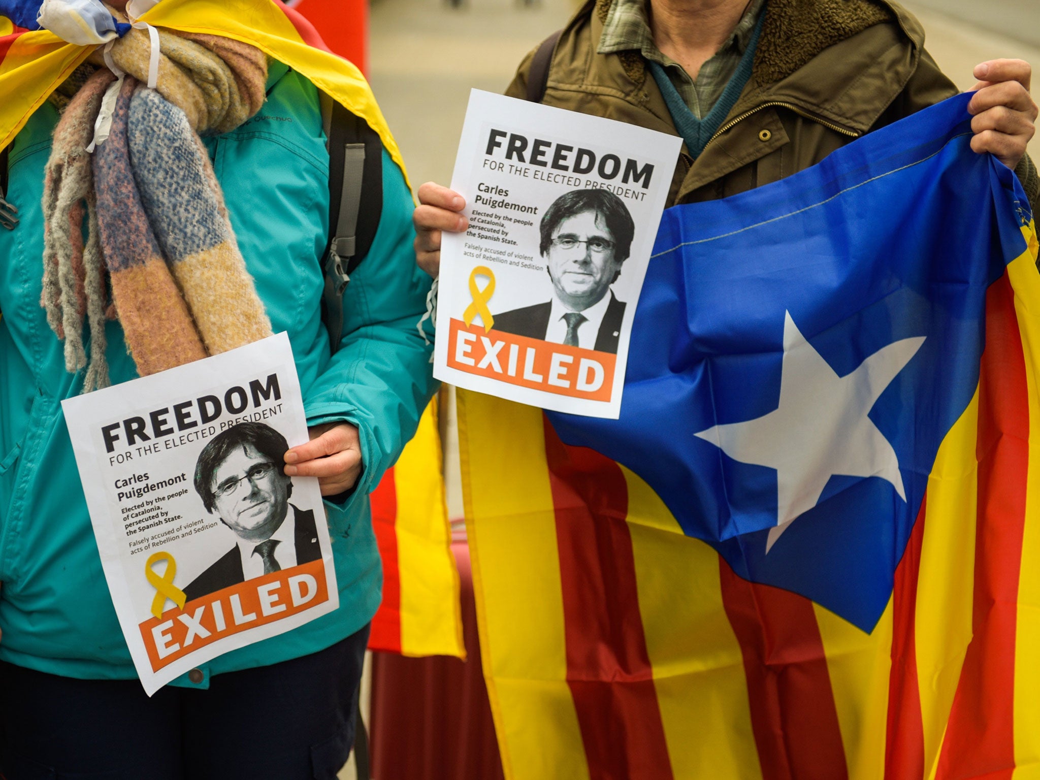 Demonstrators hold placards showing Puigdemont, near the prison where he is being held in Neumuenster, Germany