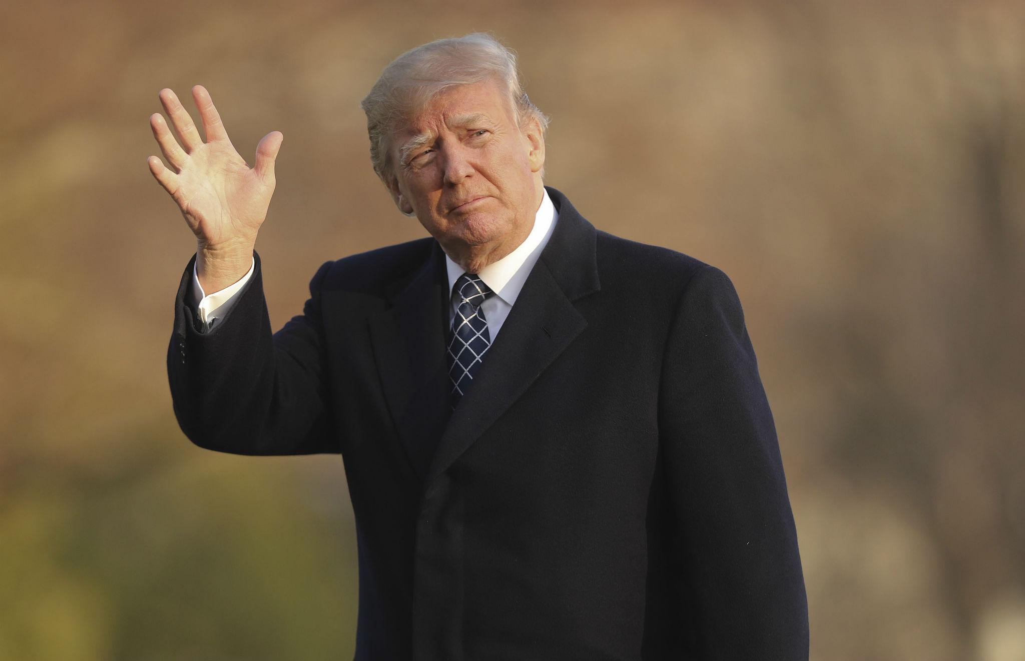 Donald Trump waves as he walks across the South Lawn of the White House in Washington