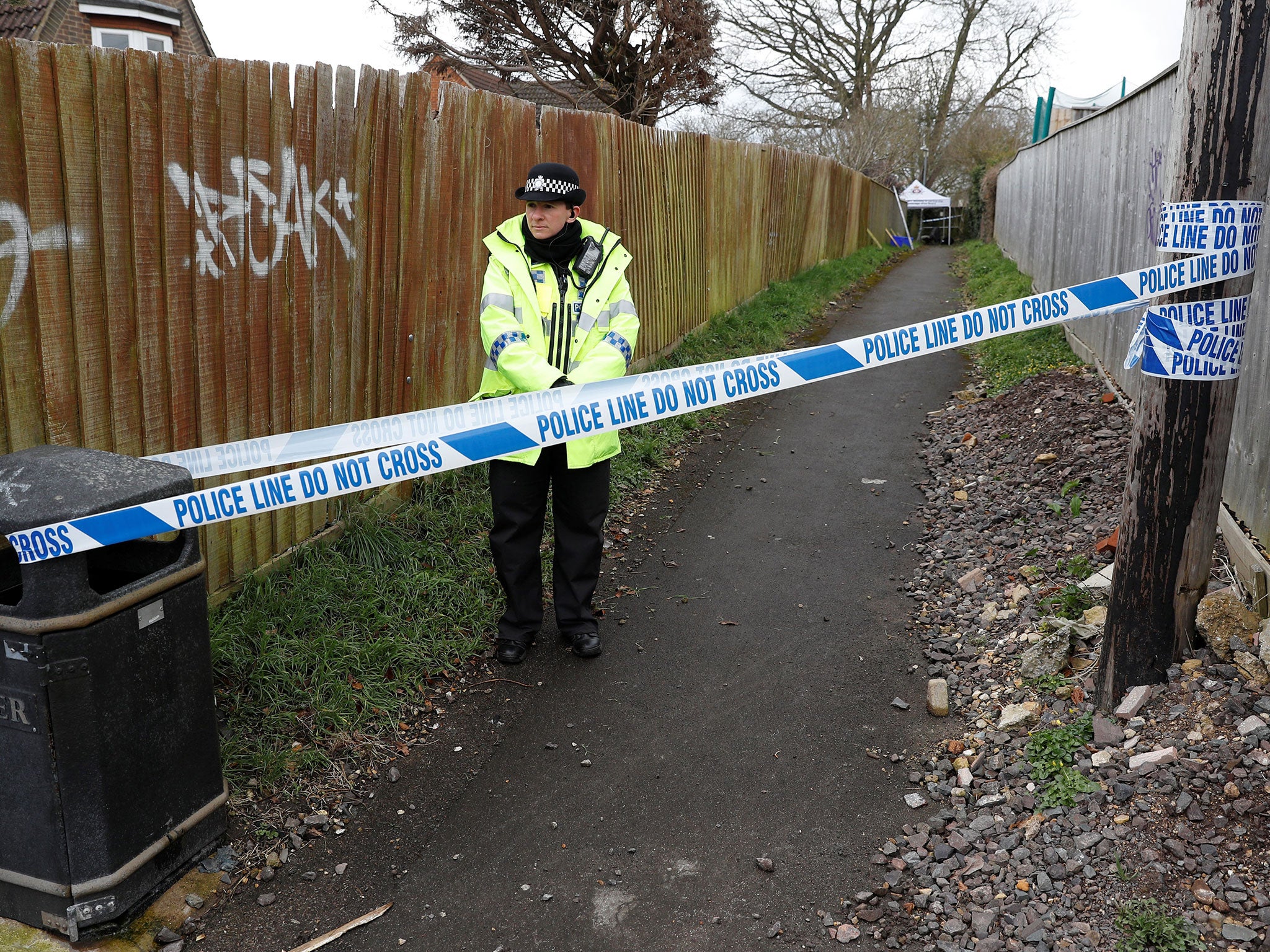 A police officer stands behind cordon tape in an alleyway which has been blocked off near the home of former Russian intelligence officer Sergei Skripal in Salisbury