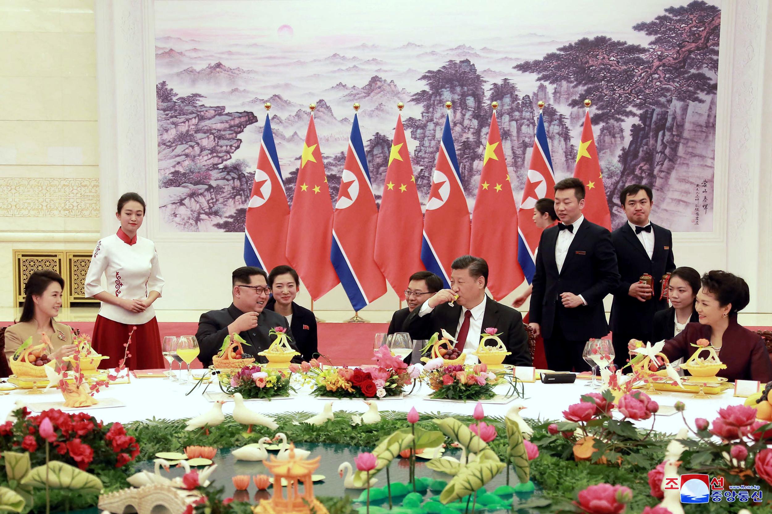 From left to right: North Korea's leader, Kim Jong-un, and his wife Ri Sol-ju, left, talk with Chinese counterpart Xi Jinping, and his wife Peng Liyuan, at the Great Hall of the People in Beijing