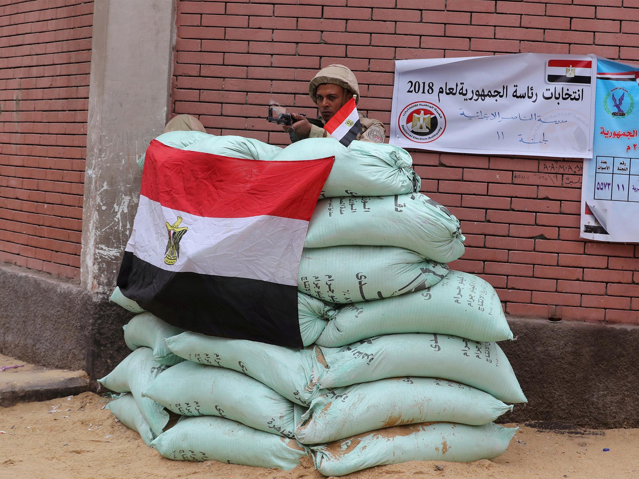 An Egyptian army soldier stands guard outside a polling station in Cairo