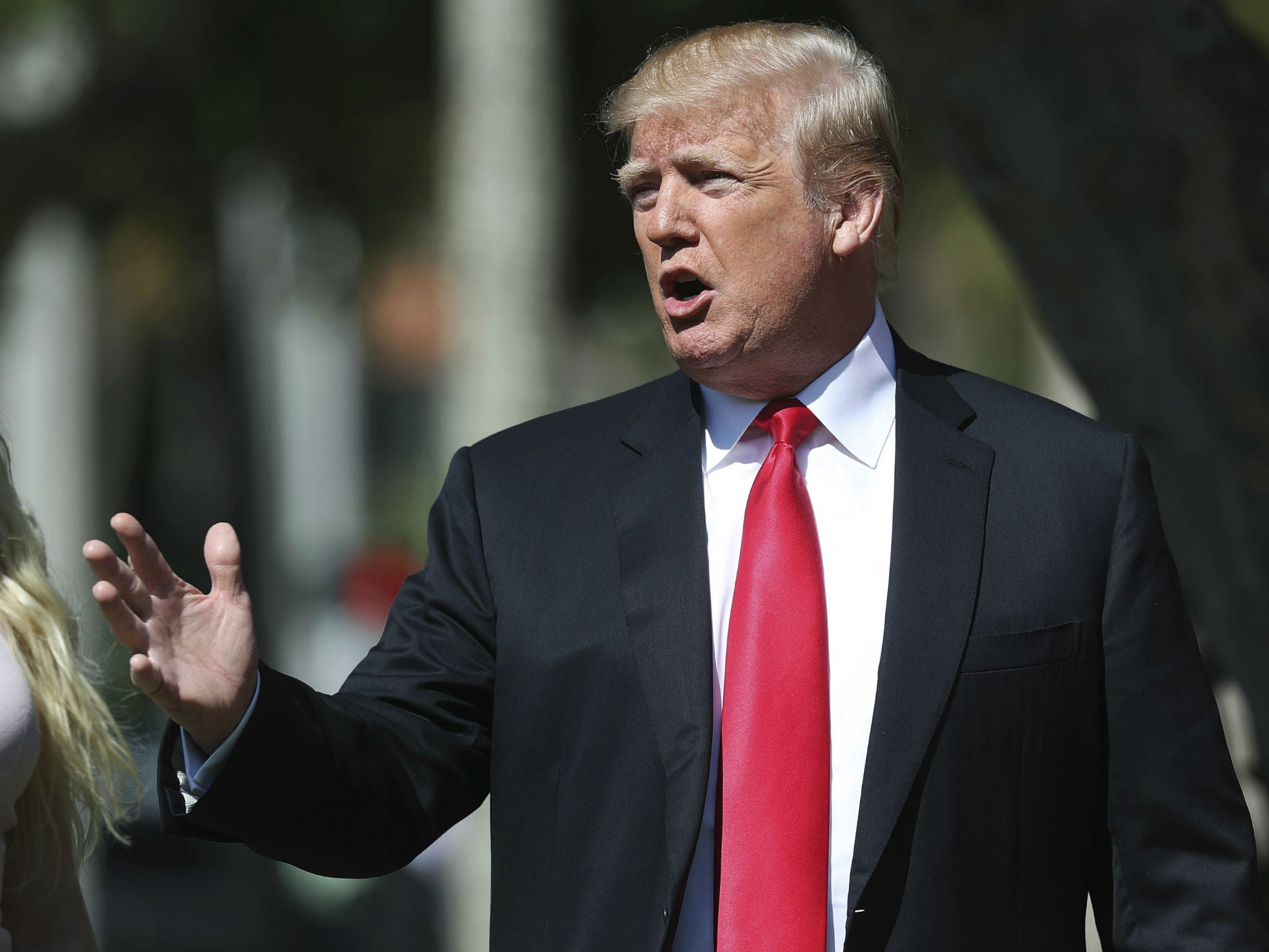 Donald Trump stops to speak to members of the media as he arrives for Easter services in Palm Beach, Florida