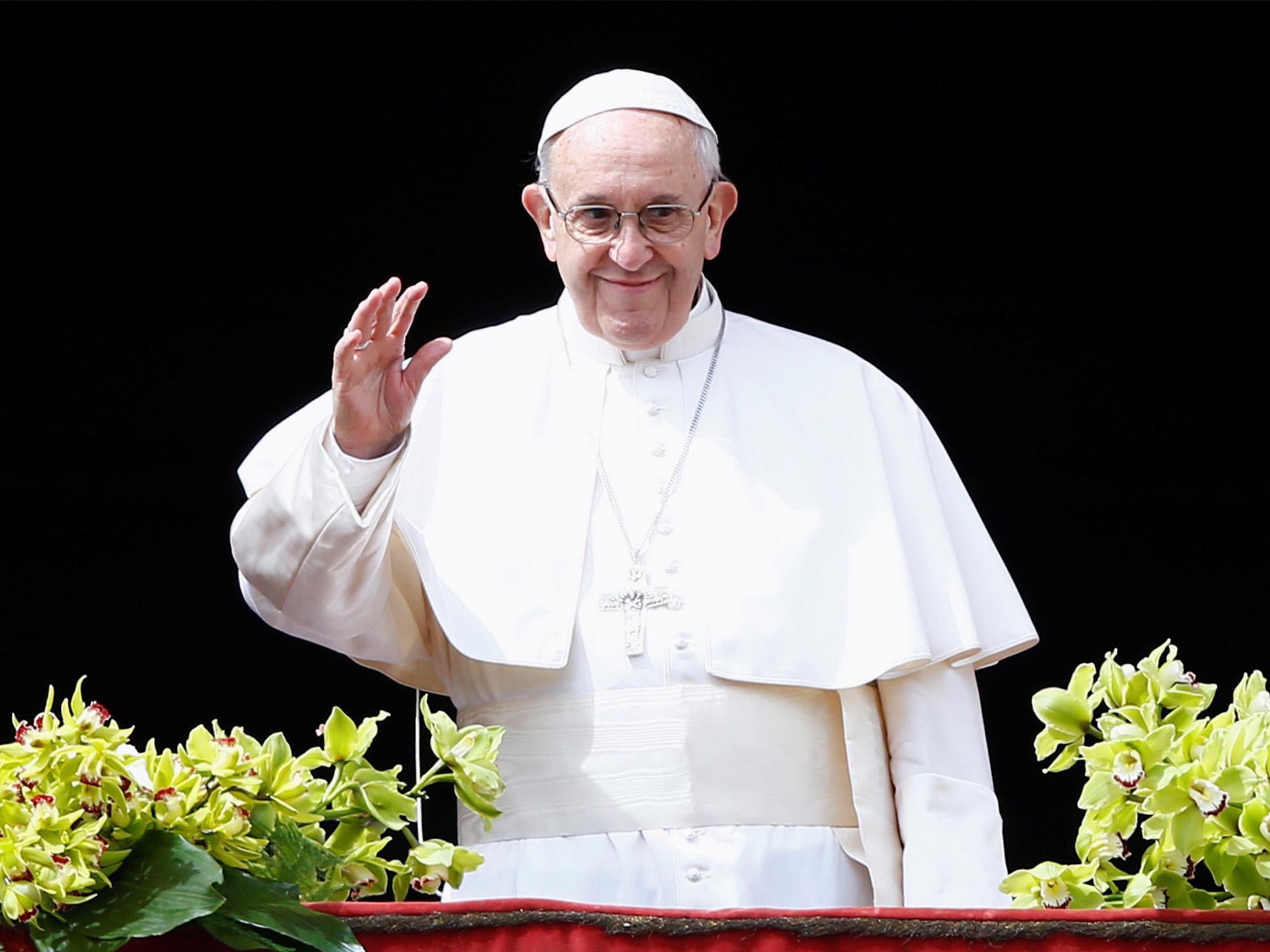 Pope Francis waves to the crowd before delivering his Easter message from the Vatican