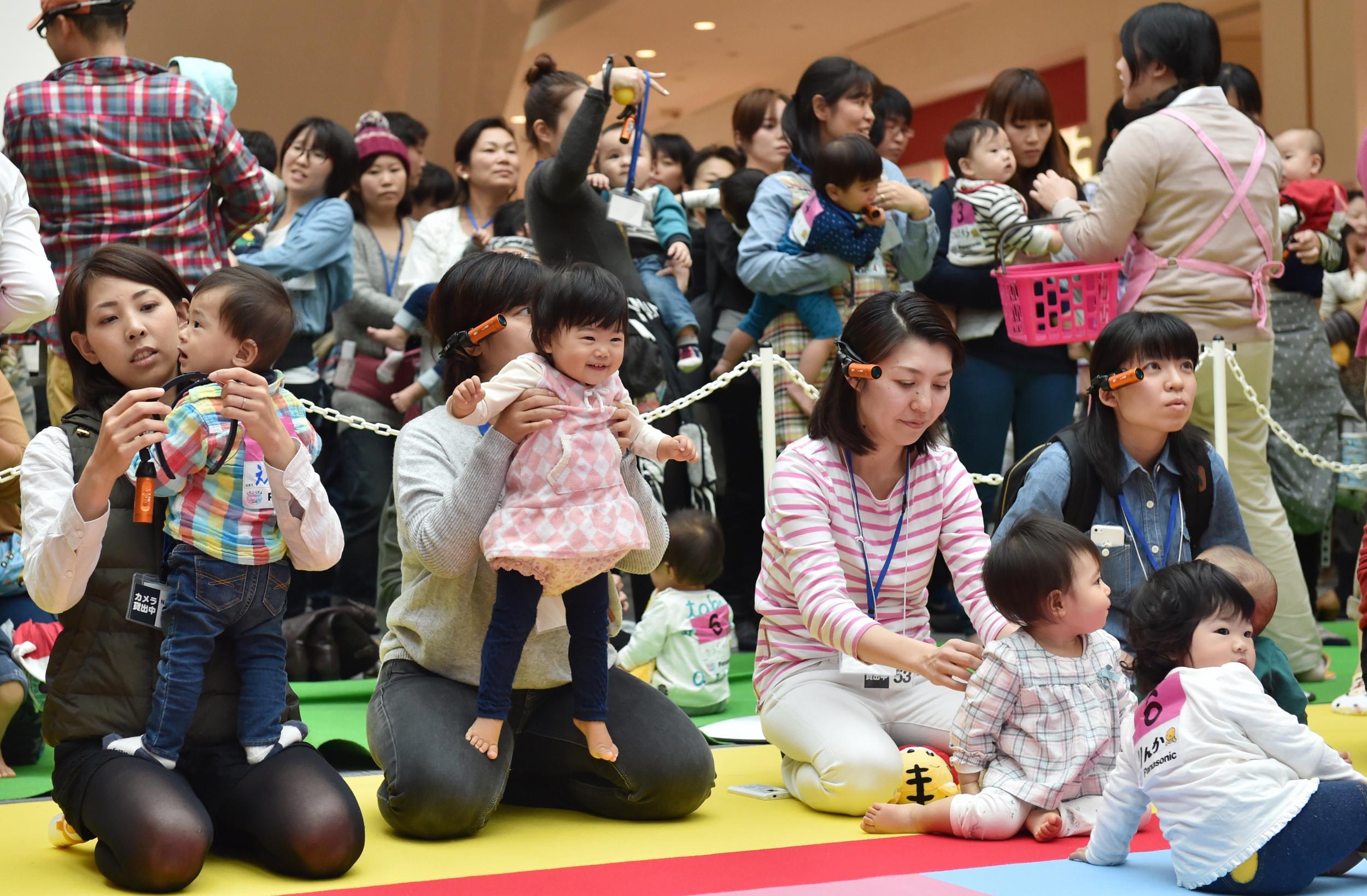 Babies and their mothers take part in a baby crawling competition in Yokohama