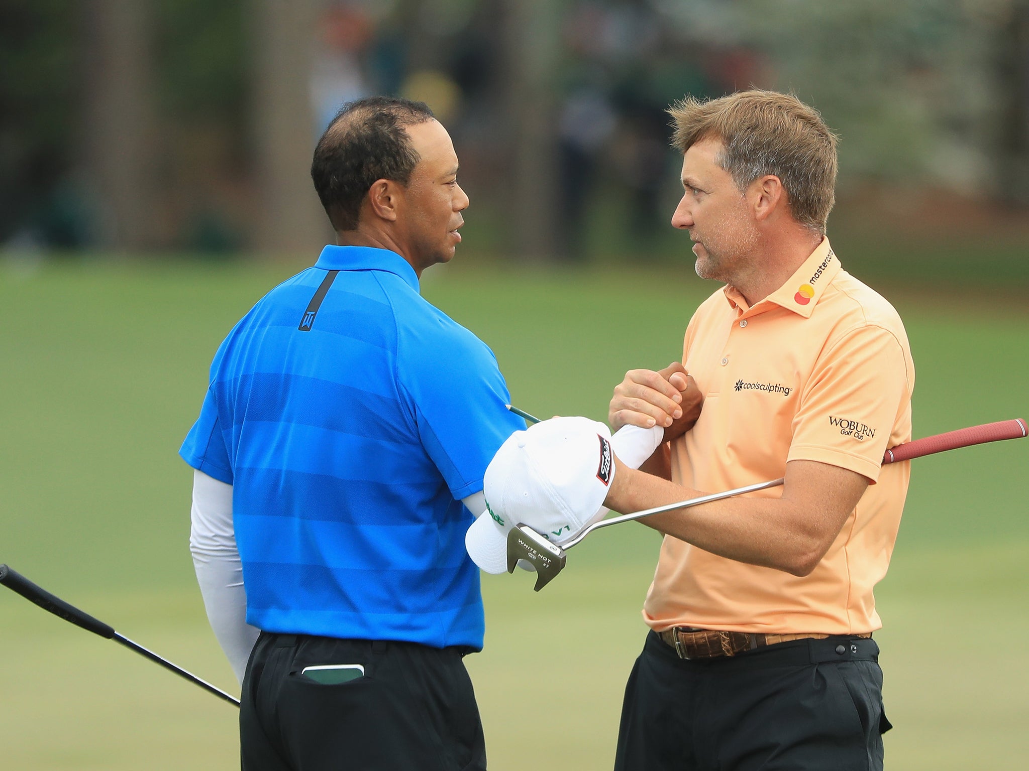 Tiger Woods shakes hands with playing partner Ian Poulter