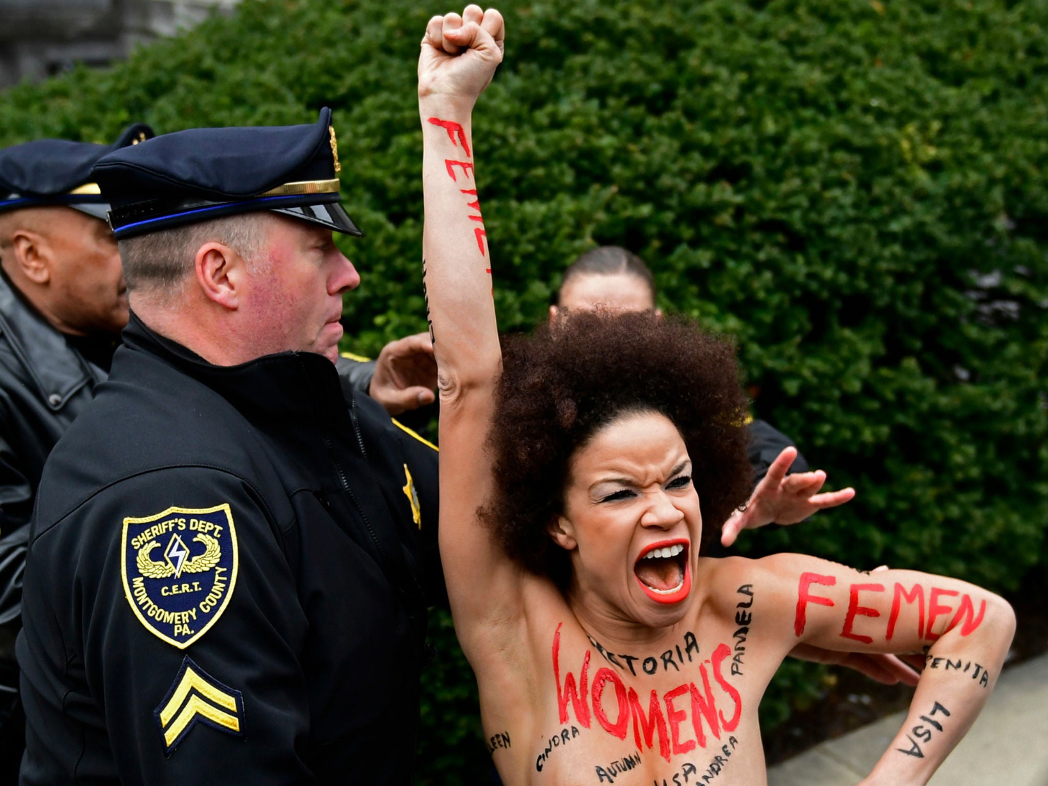 A protester is detained as Bill Cosby arrives for his sexual assault trial at the Montgomery County Courthouse