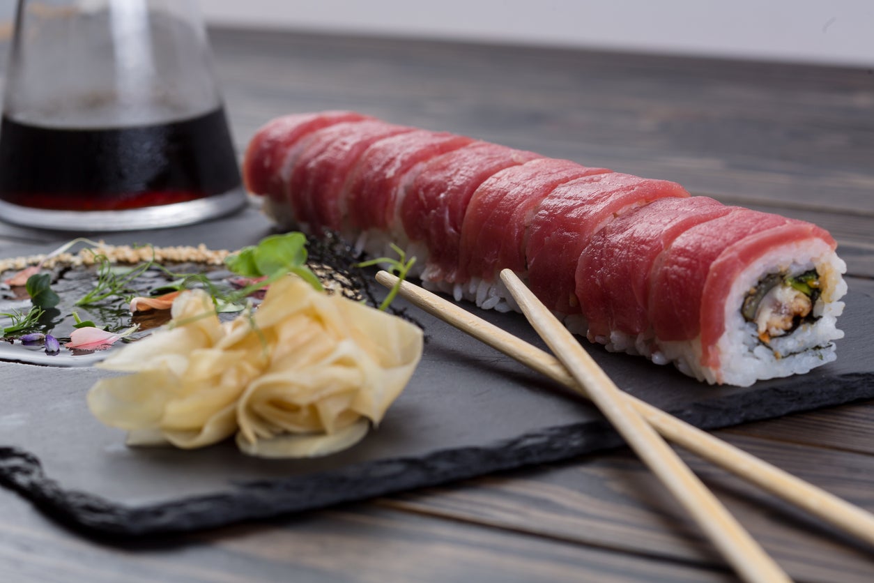 Sushi is best enjoyed freshly made and eaten while standing, with numerous joints around the city (Getty)