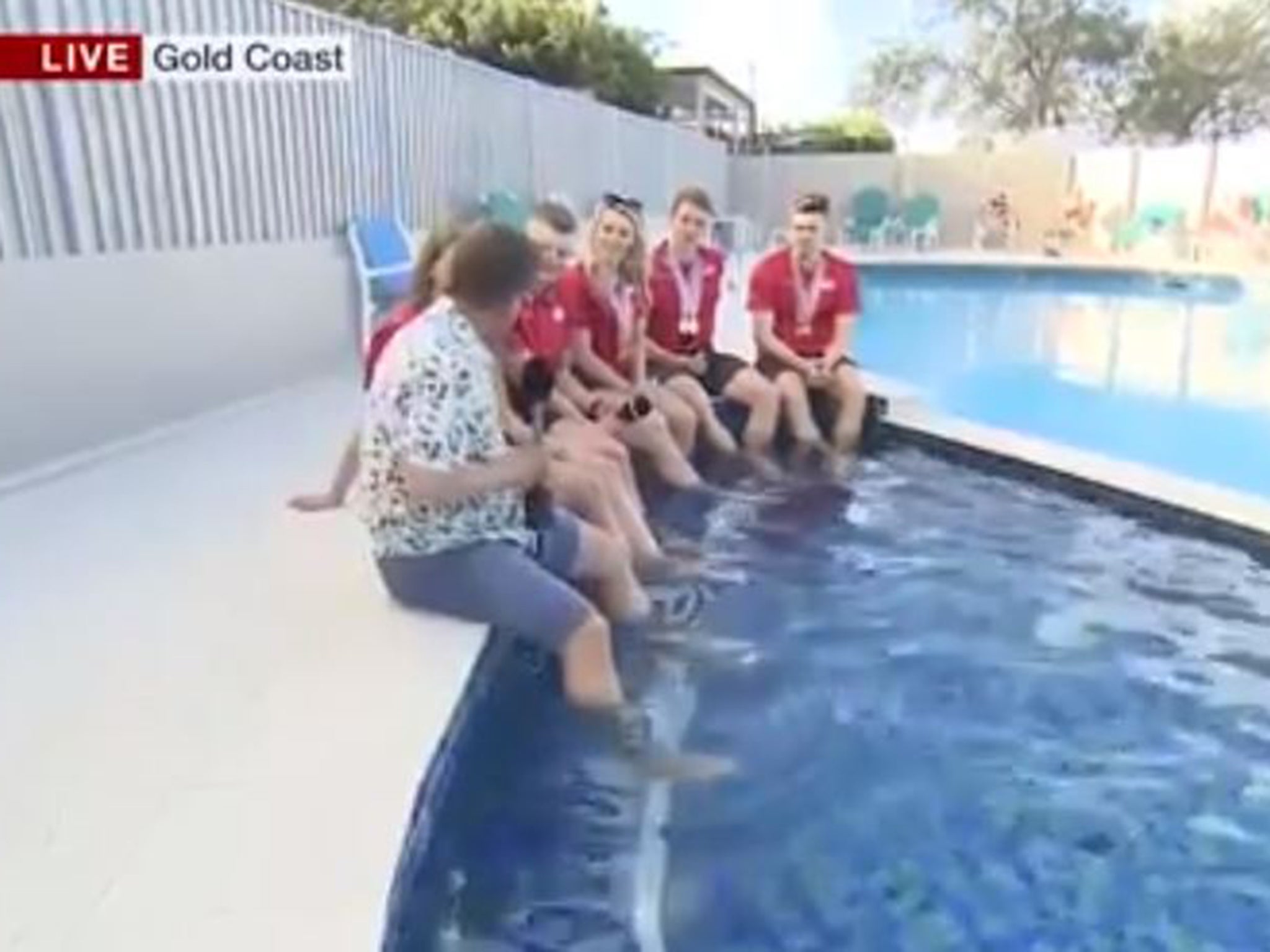 Bushell took a seat on ledge of the pool alongside the swimmers