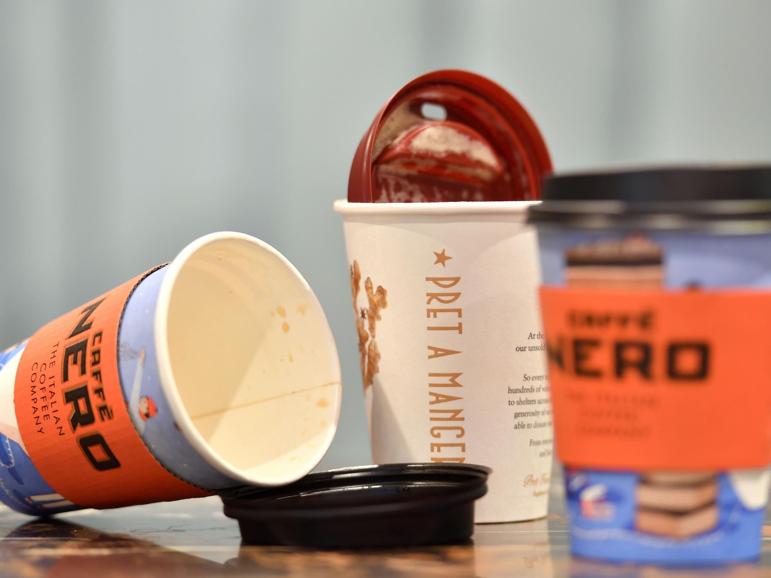 Disposable coffee cups are left on a table in a cafe in central London