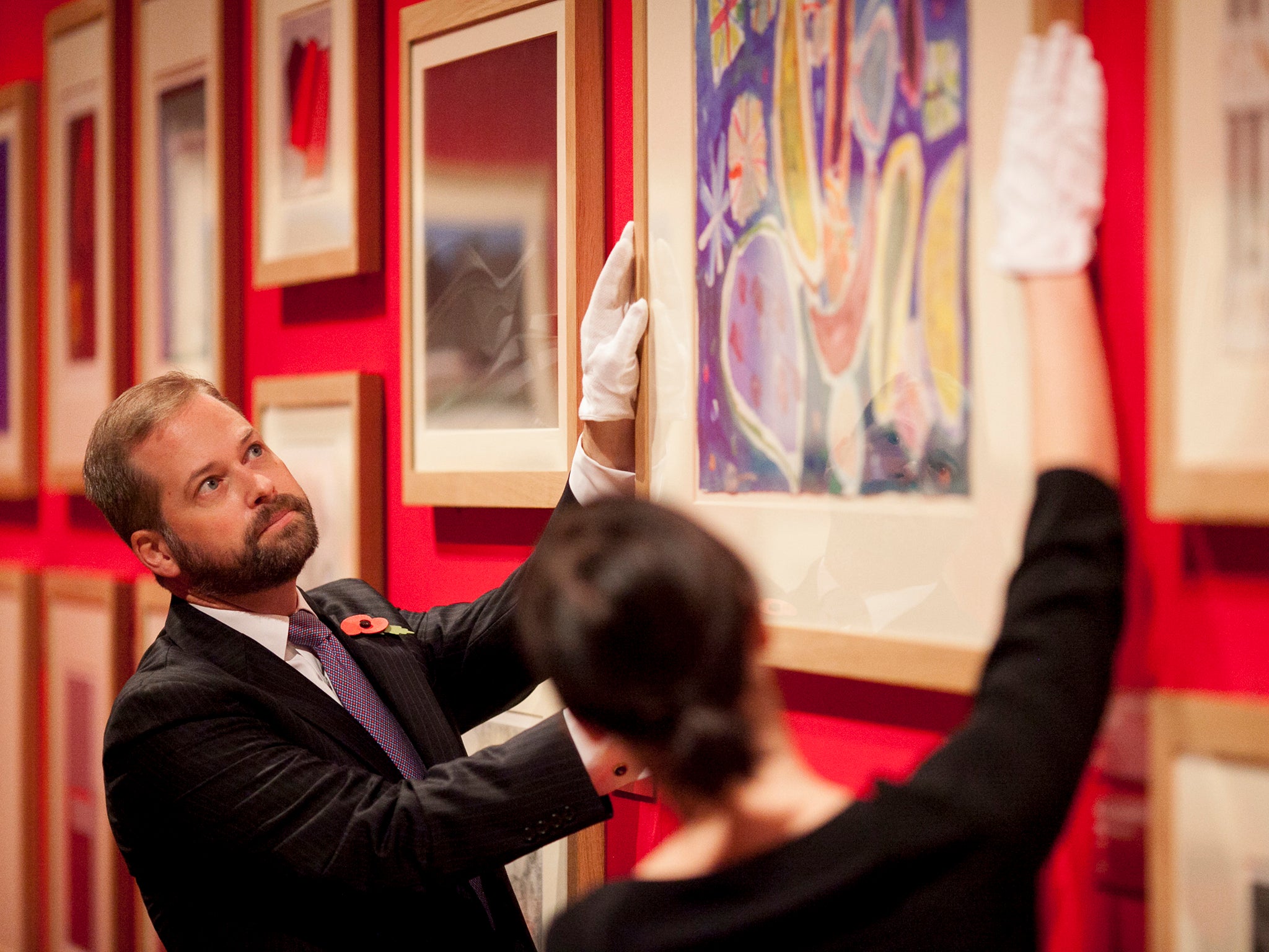 Members of staff straighten one of Ayres’ paintings at The Queen’s Gallery (Getty )