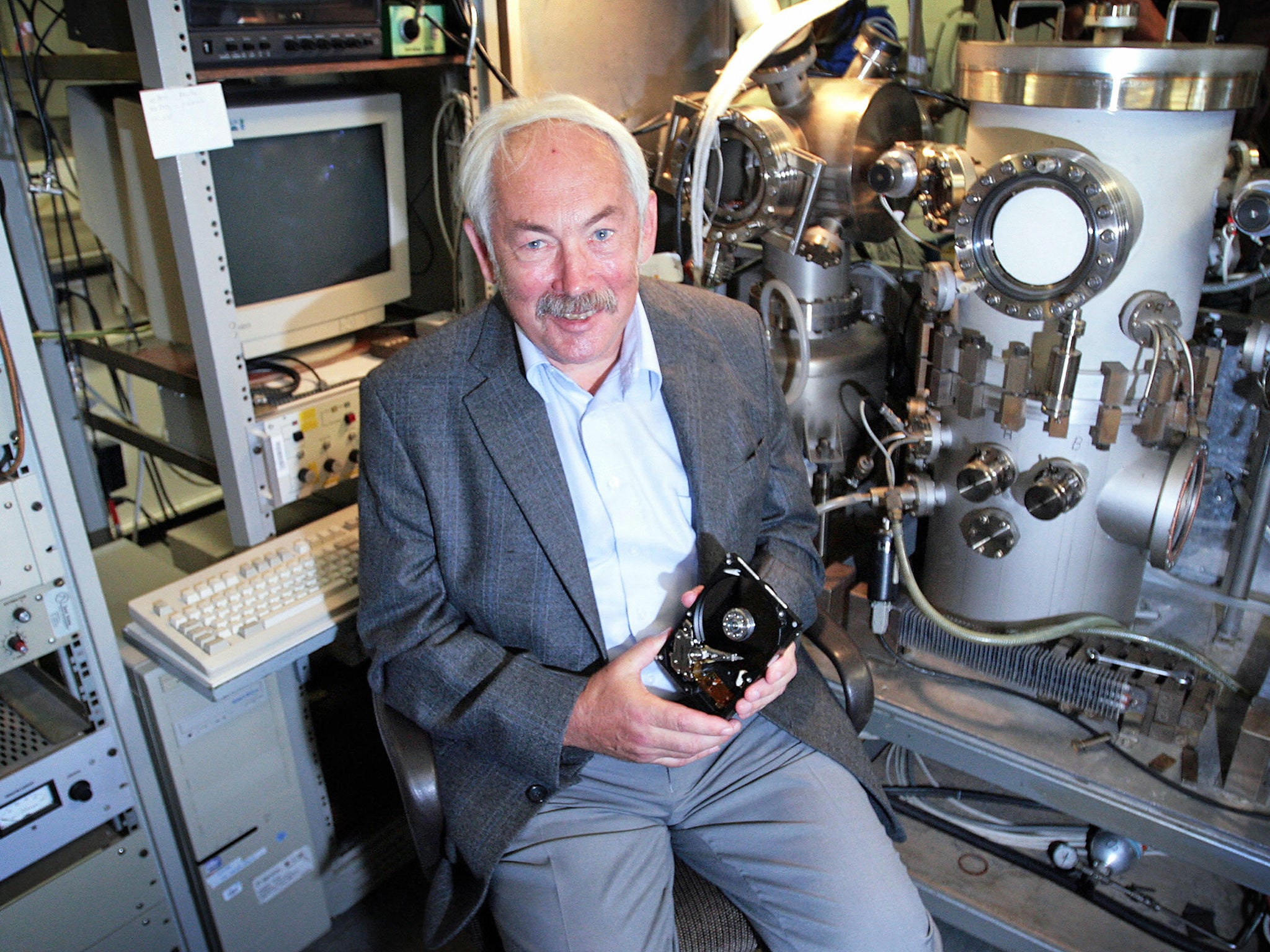 Grünberg holds a hard disk in his laboratory at the research institute in Juelich