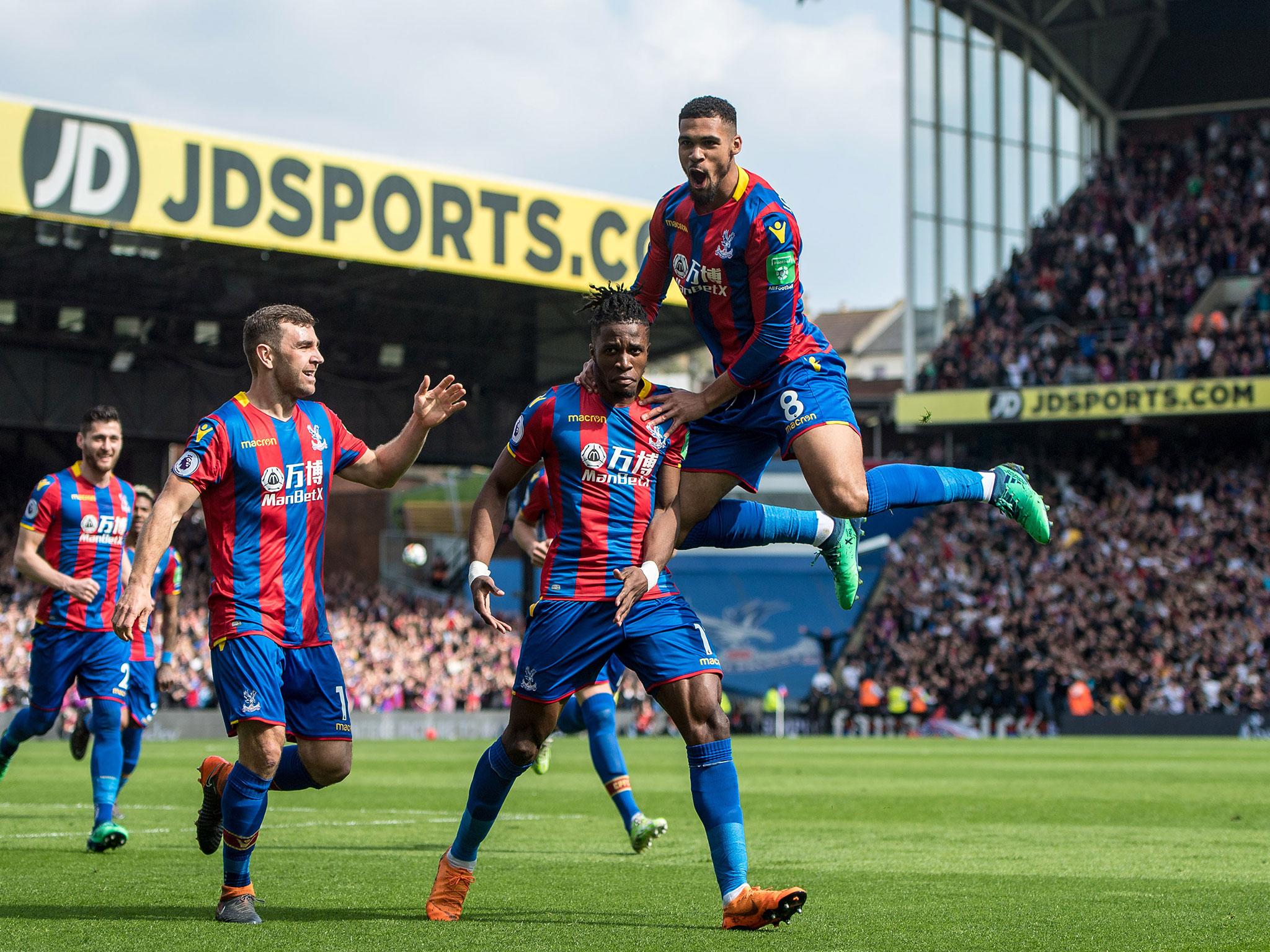 Wilfried Zaha celebrates with his teammates after scoring Palace's third