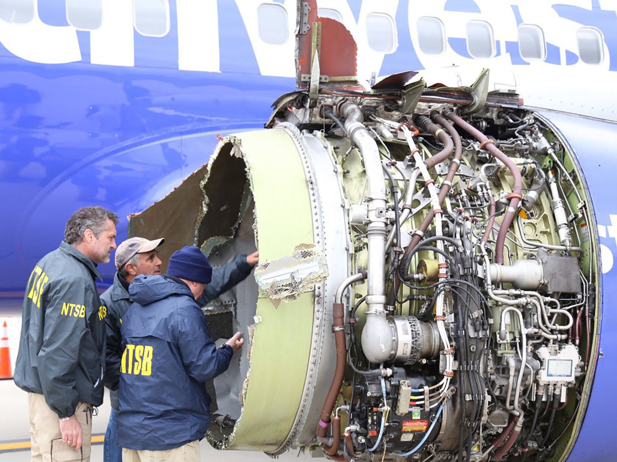 Investigators inspect the engine that exploded mid-flight