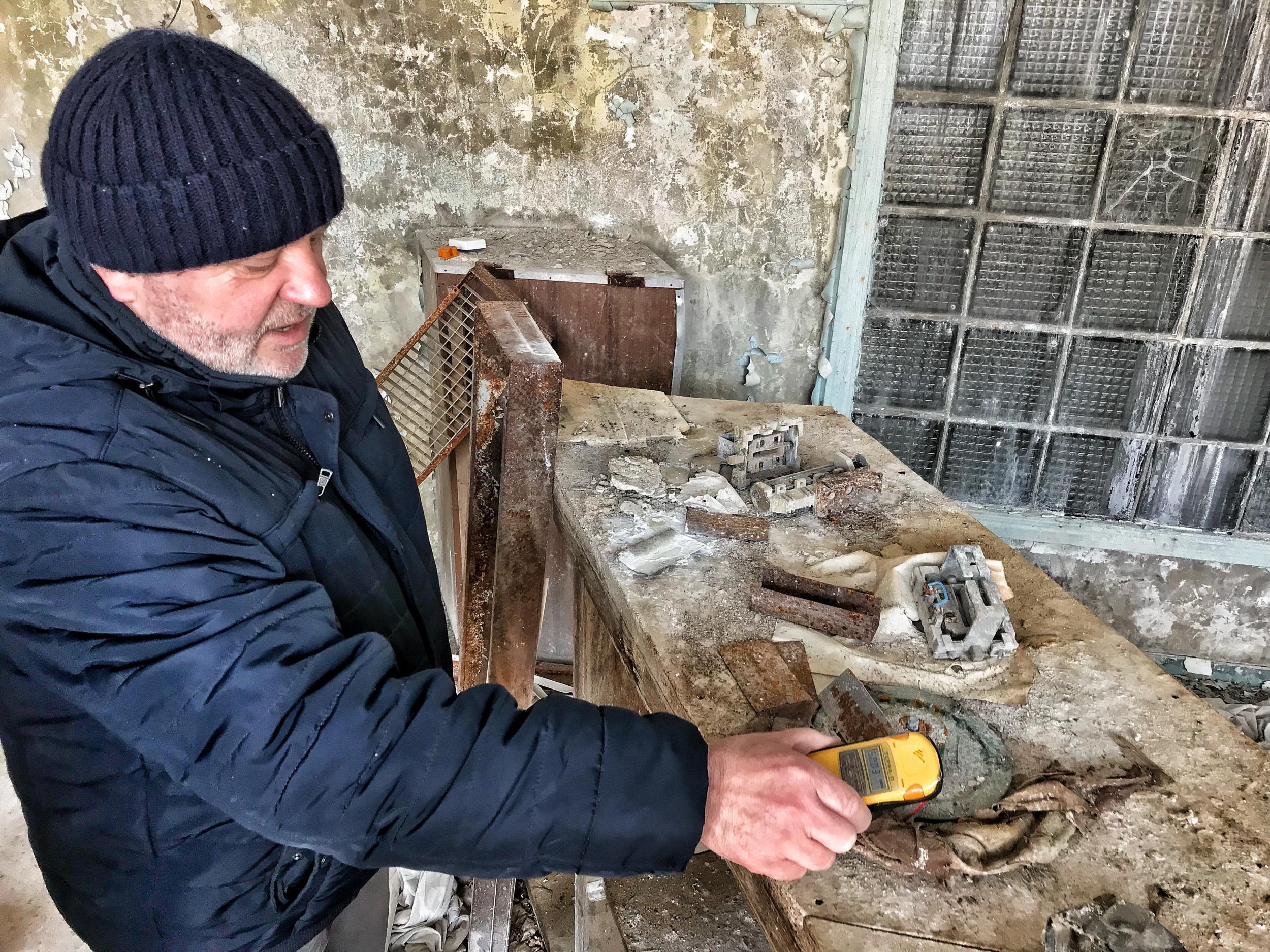 Serhii Uzlov takes a (large) millisievert reading of clothing worn by the first responders to the Chernobyl disaster