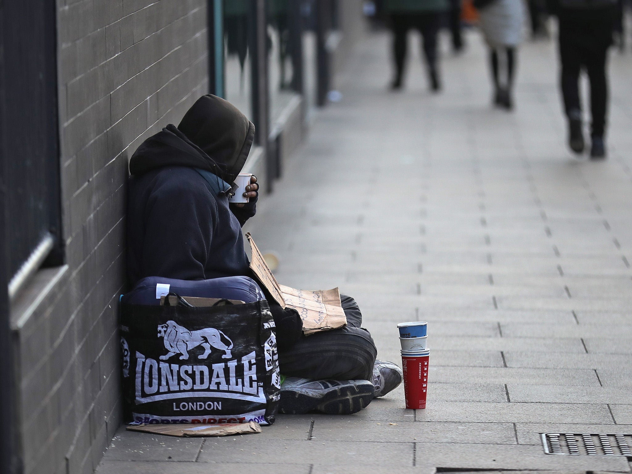 A homeless man begs for small change on the streets of Manchester