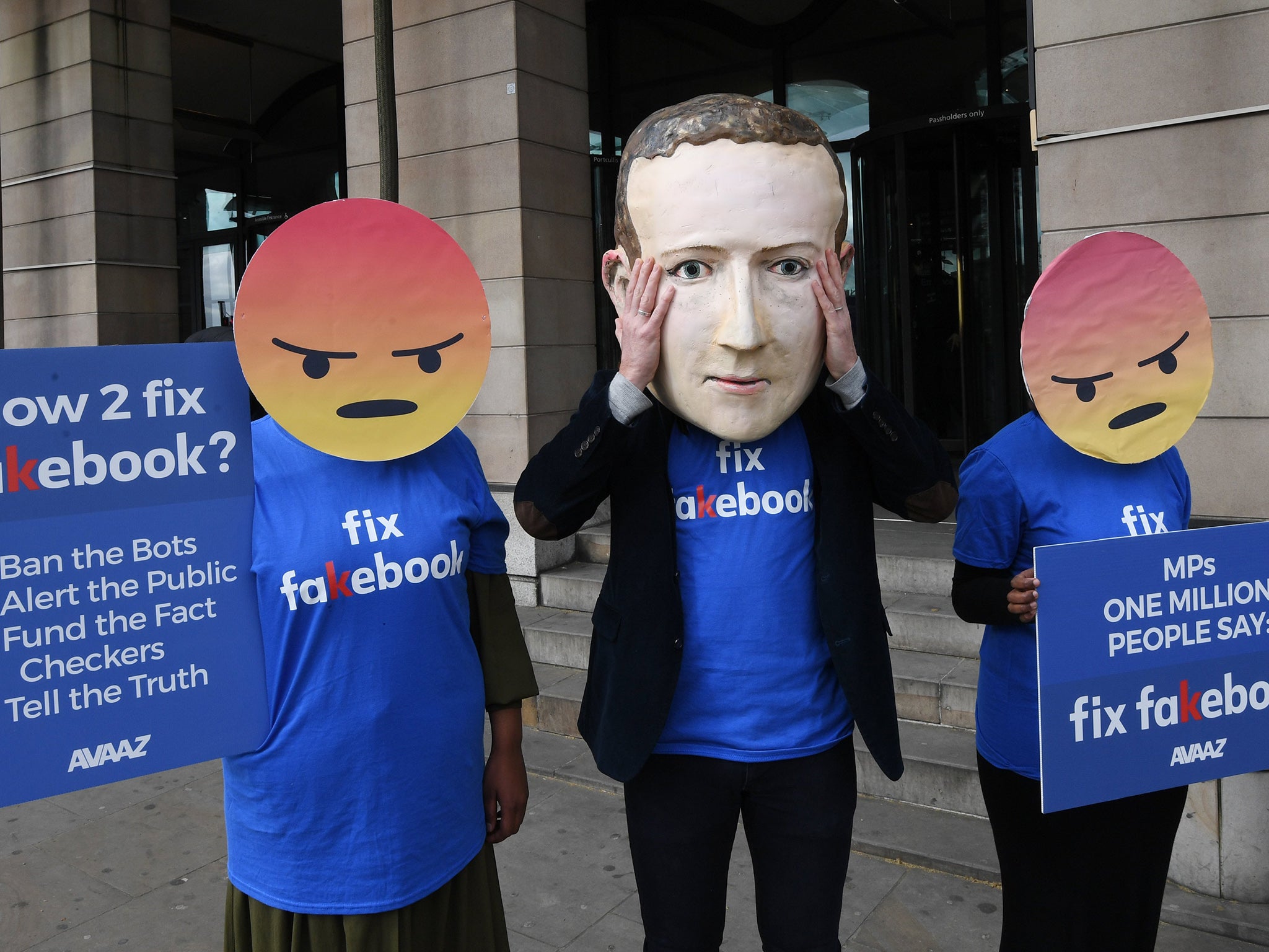 A protester wears a mask of Facebook boss Mark Zuckerberg in 2018