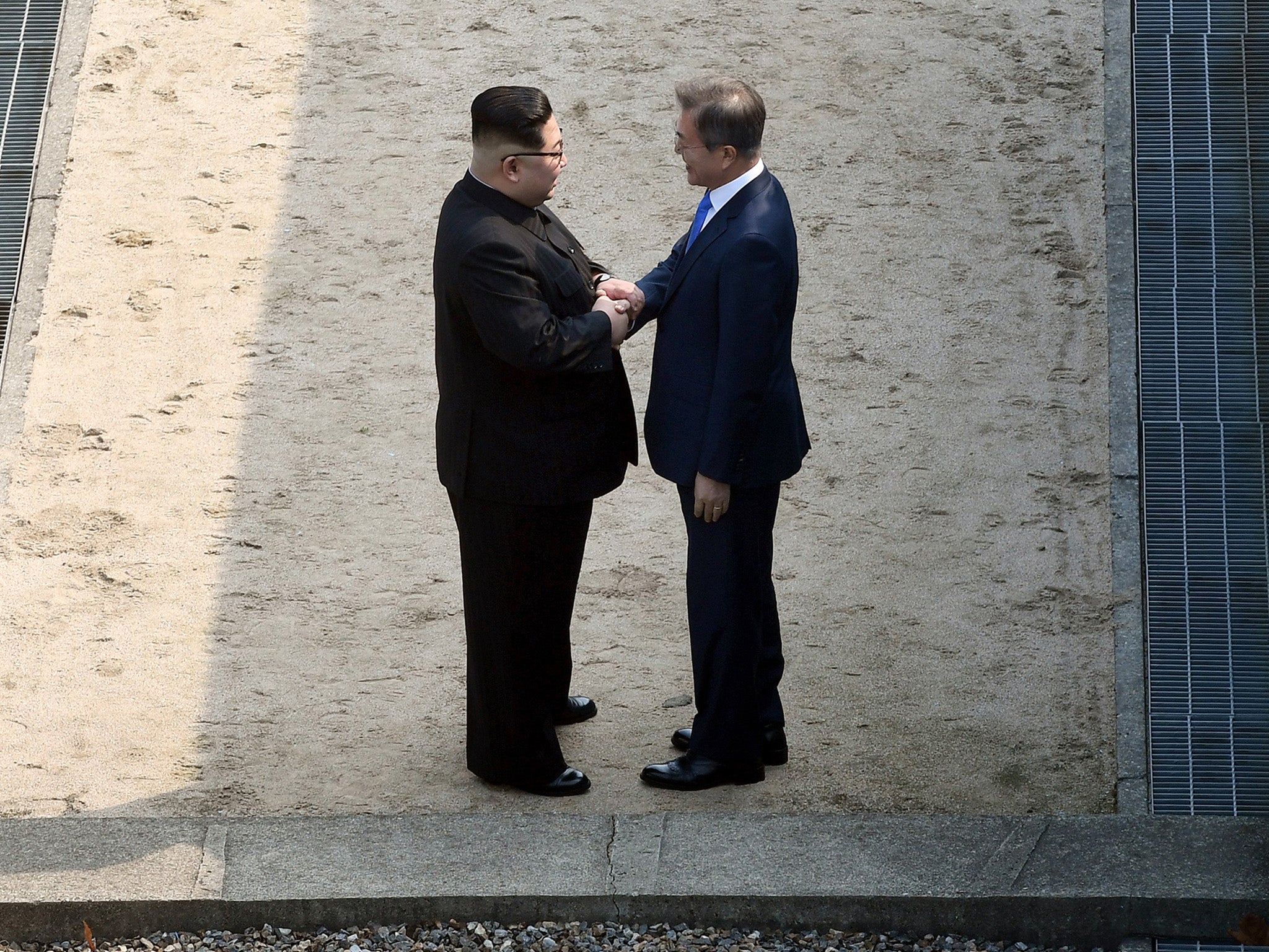 North Korean leader Kim Jong Un (L) and South Korean President Moon Jae-in (R) shake hands