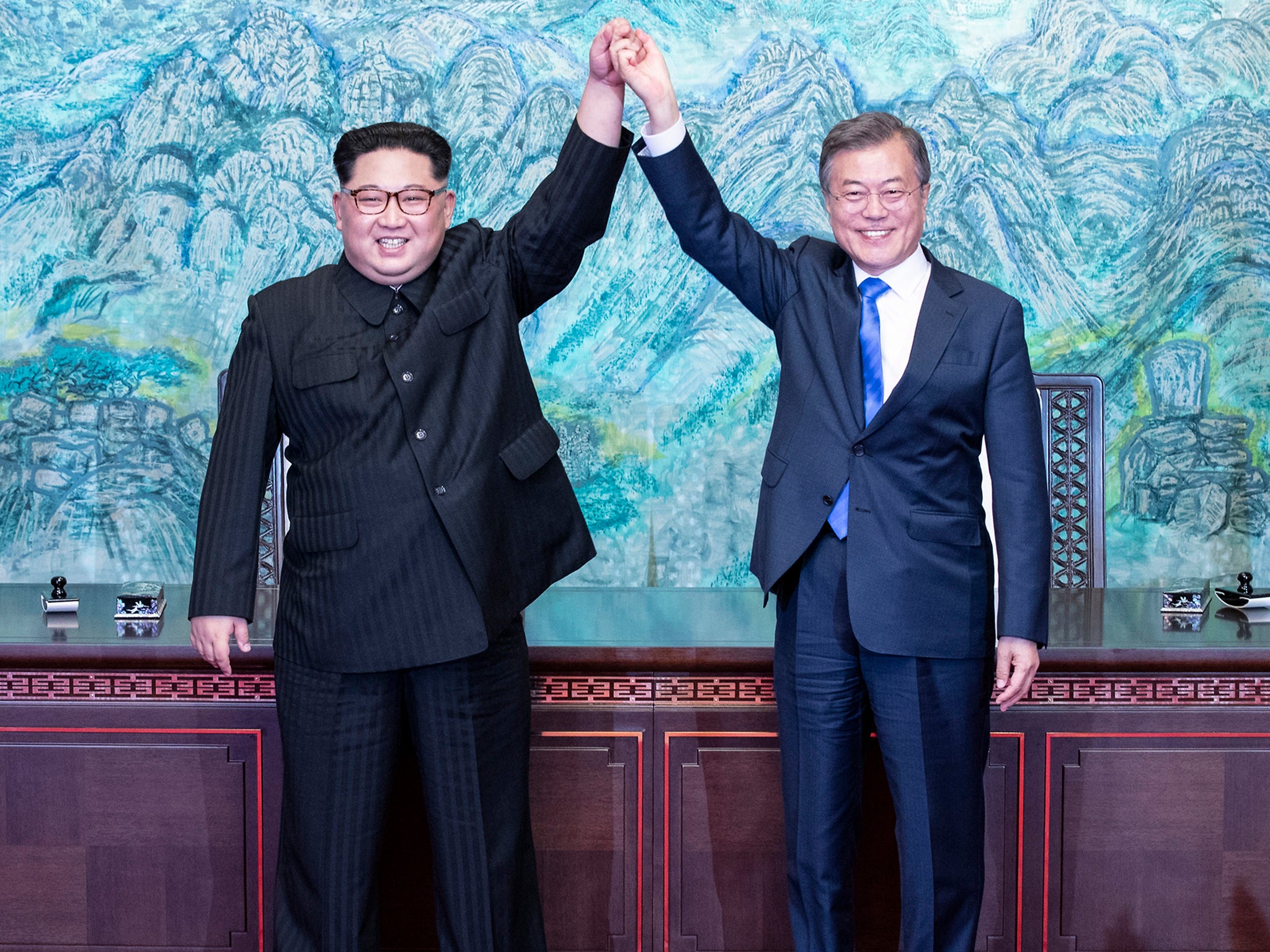 North Korean leader Kim Jong-un and South Korean President Moon Jae-in raise their hands after signing on a joint statement