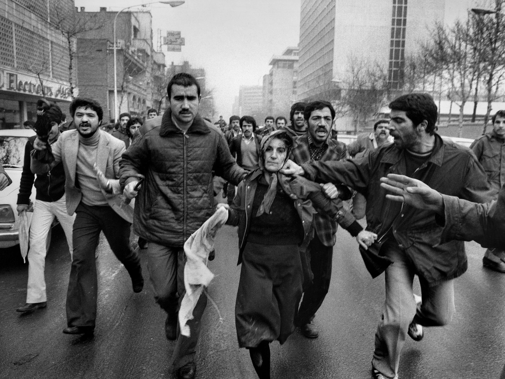 A woman believed to be a supporter of the Shah is assailed by male revolutionaries in Tehran on 25 January 1979