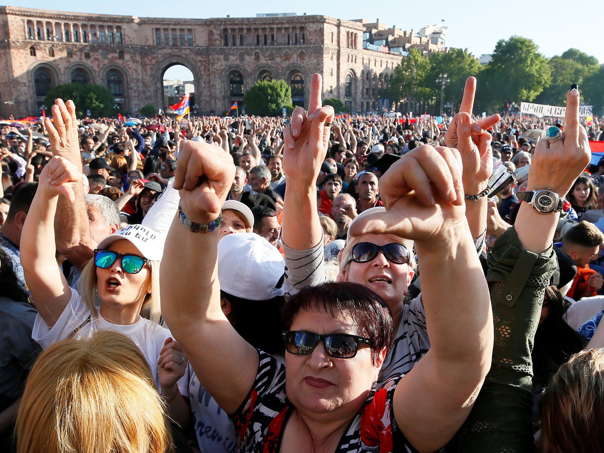 Supporters of Armenian opposition leader Nikol Pashinyan react as they watch a live broadcast of a parliament session to elect an interim prime minister in central Yerevan