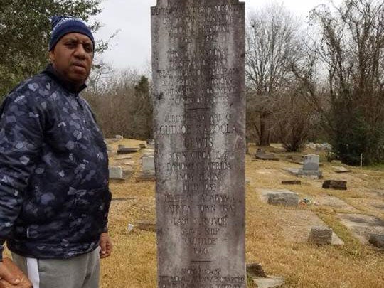 Garry Lumbers beside the grave of his great-great grandfather Cudjo Lewis