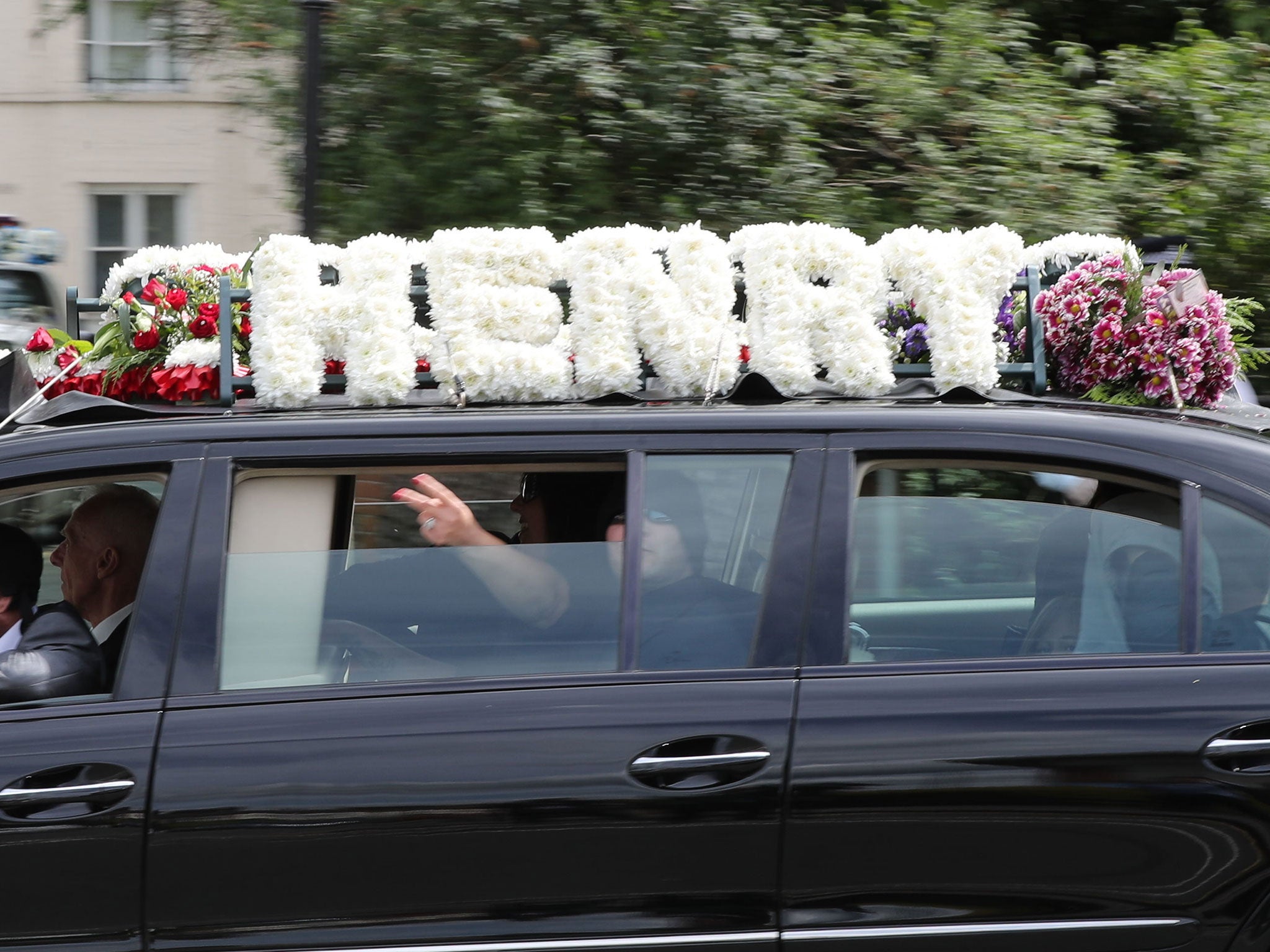 A passenger gestures from a vehicle that forms part of the funeral cortege of burglar Henry Vincent, near St Marys Church in St Mary Cray on 3 May