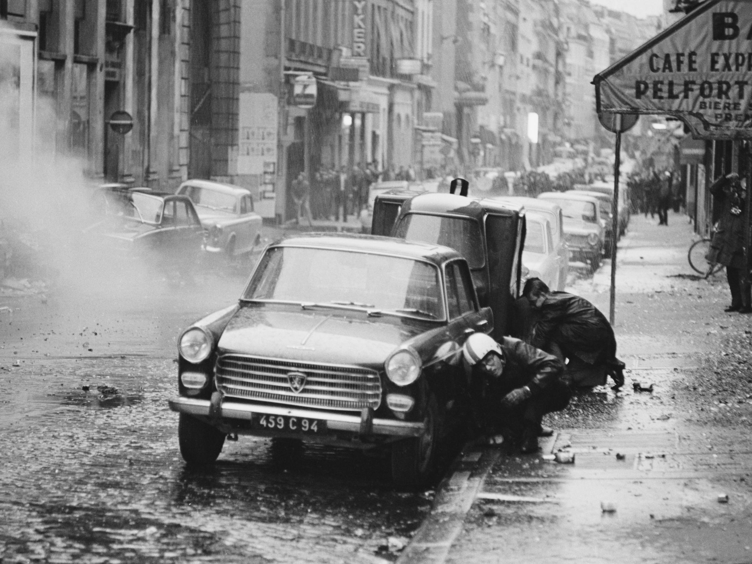 Two men take evasive action during a Paris street riot on 30 May