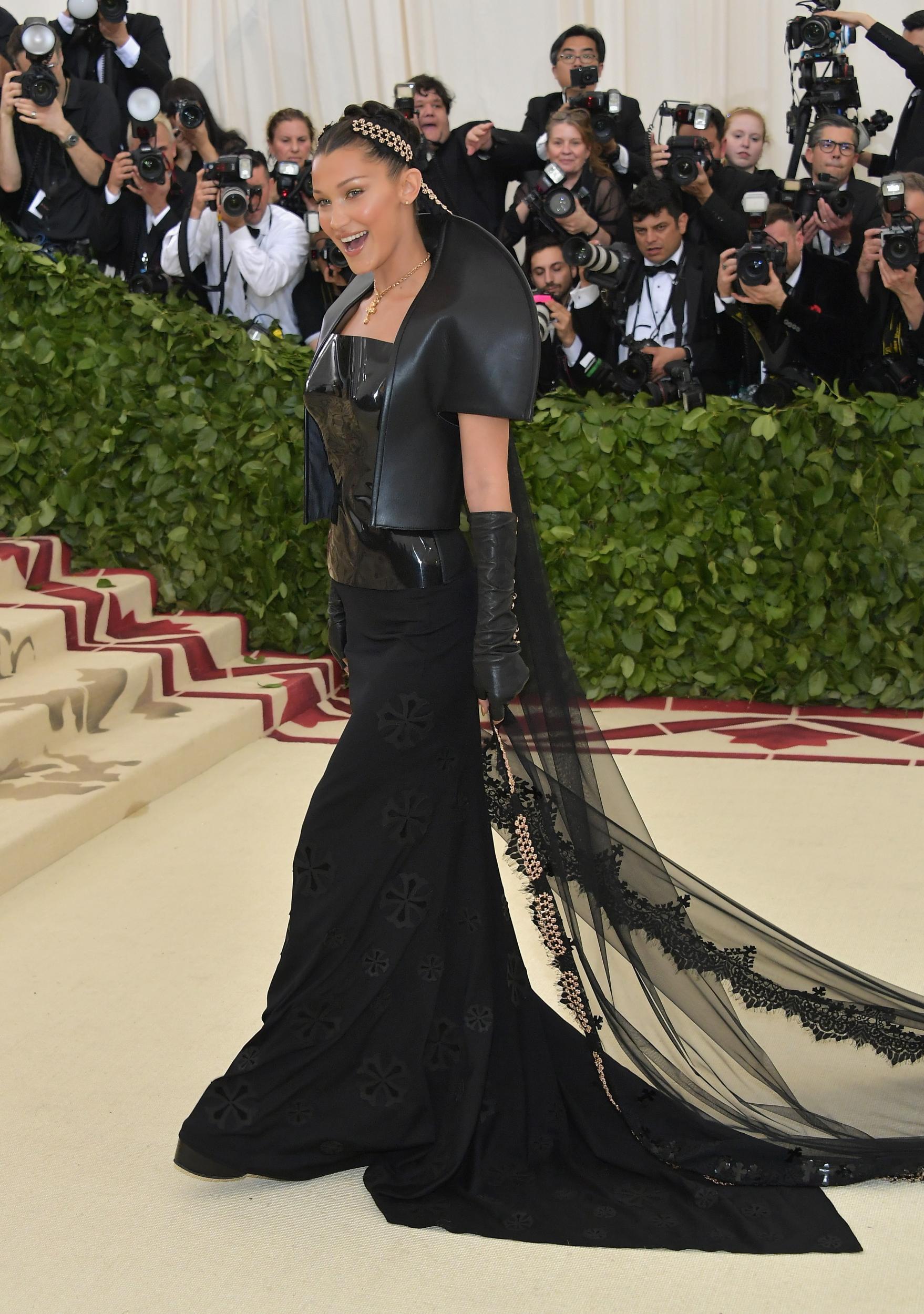 Supermodel Bella Hadid wears a glossy latex corset by Chrome Hearts Official x Gareth Pugh, topped with a sculptural cape