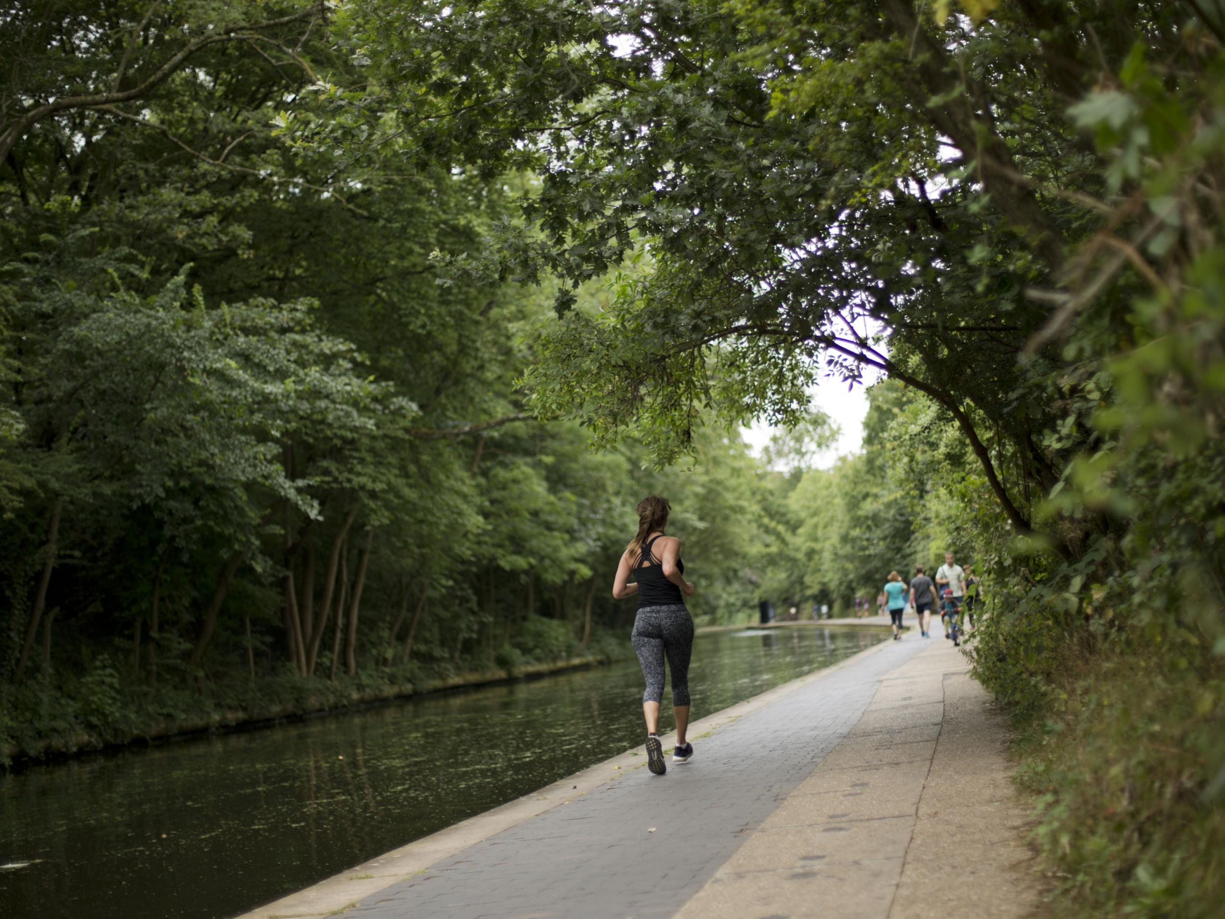 A woman jogs along the Regent's Canal towpath in London