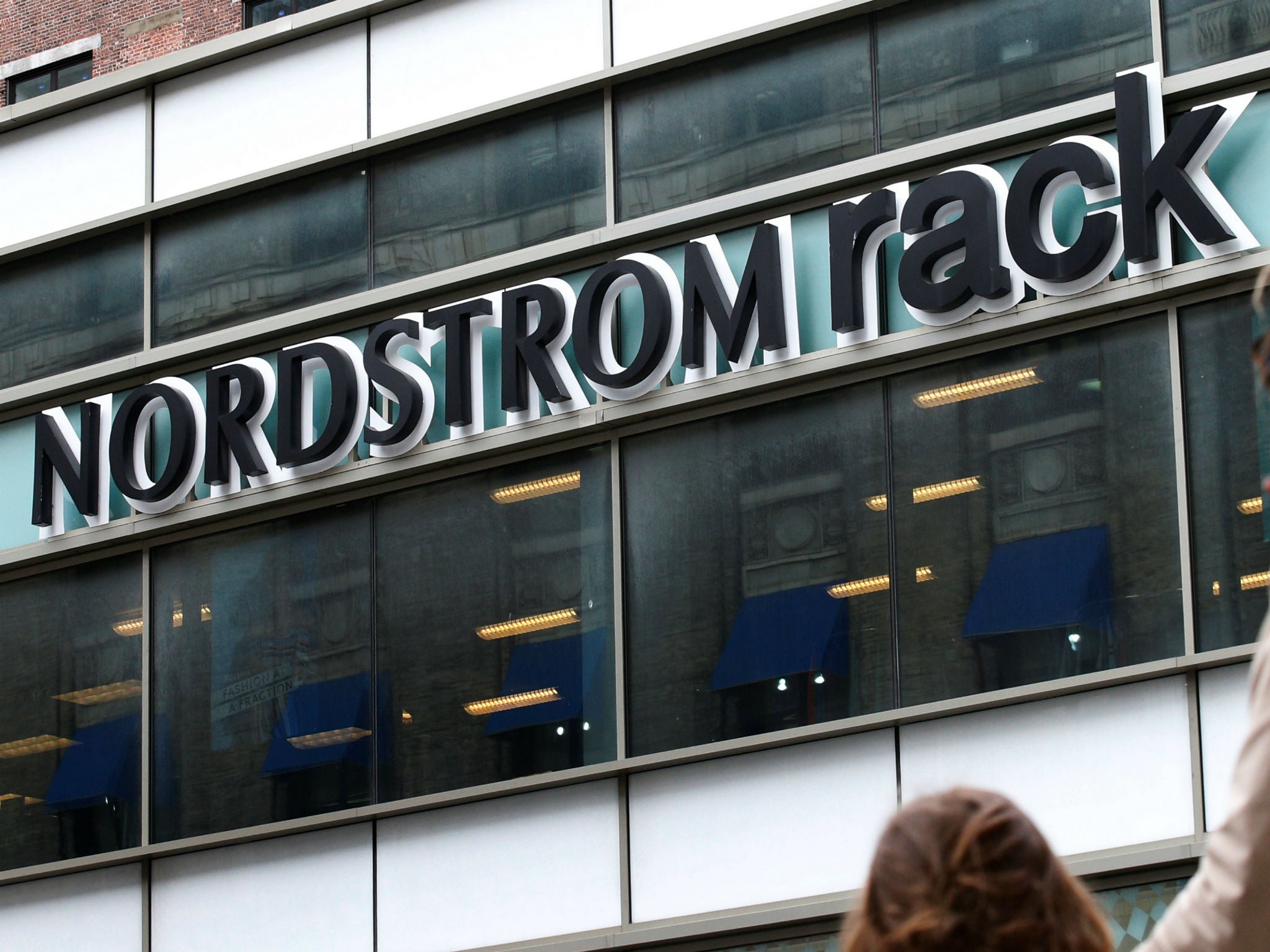 People walk by a Nordstrom Rack store in Brooklyn