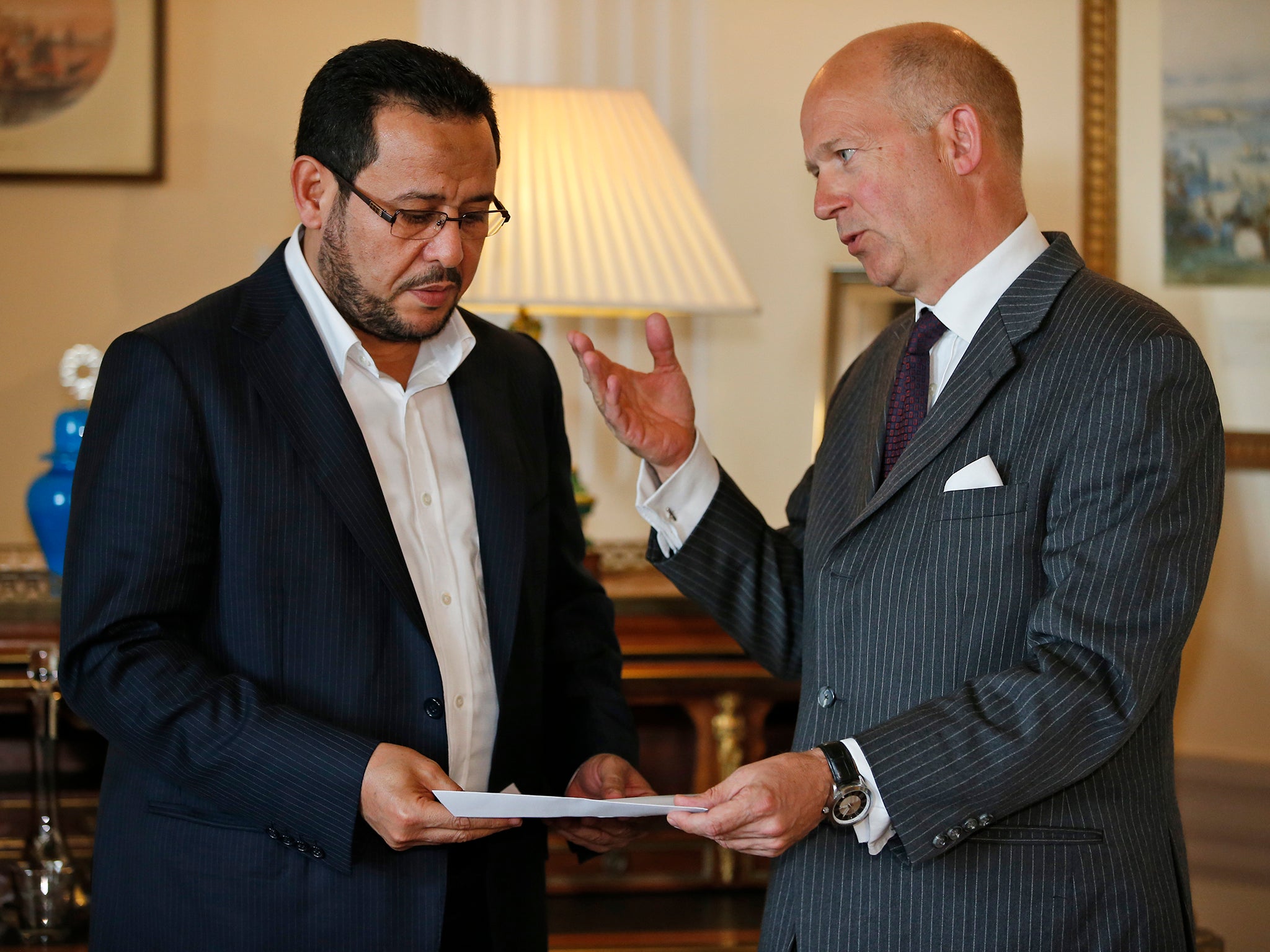 Dominick Chilcott, right, British ambassador in Turkey, hands over a letter of apology from the UK government to Libyan dissident Abdel Hakim Belhaj, at the British Consulate, in Istanbul