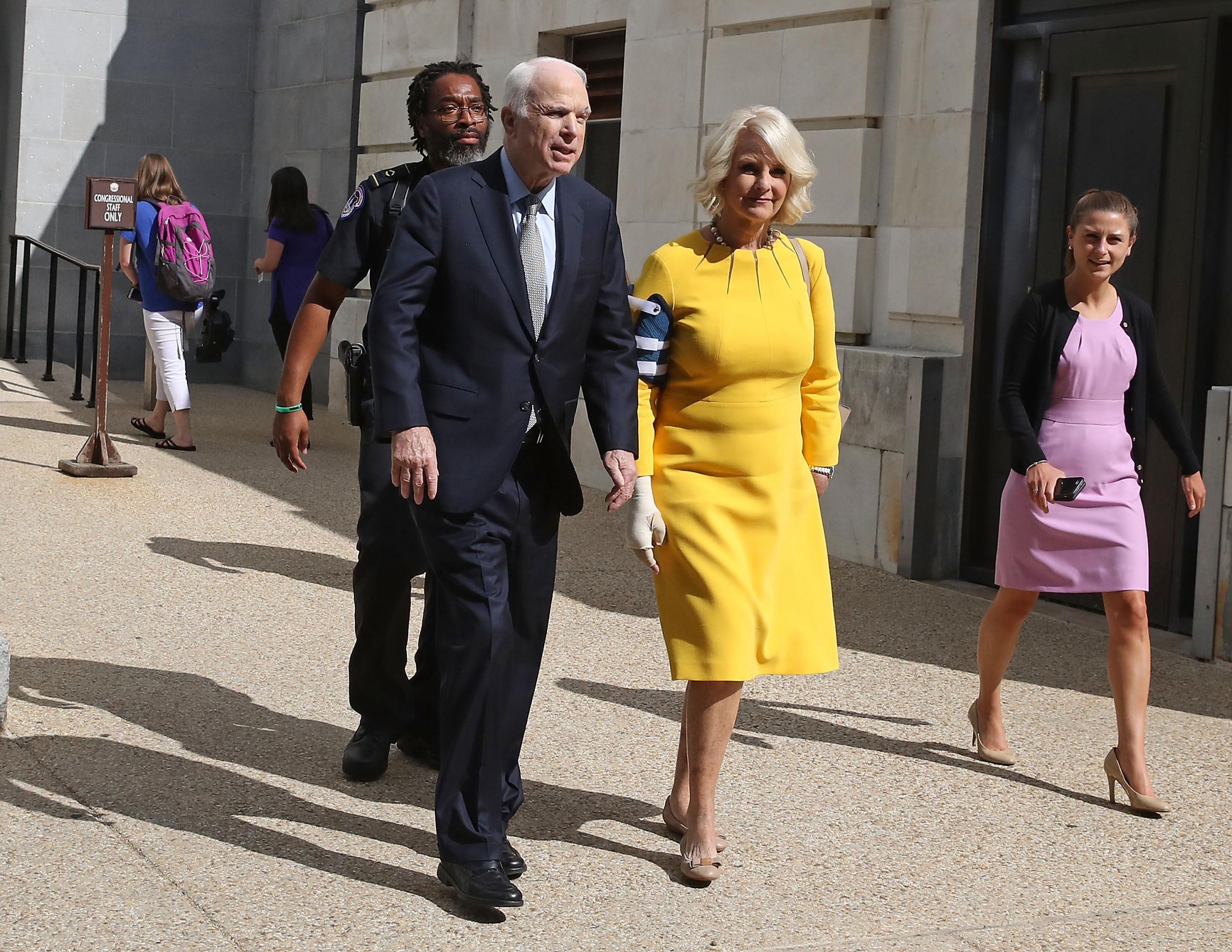 Senator John McCain and his wife Cindy McCain walk out of the Russell Senate Office building toward their car at the US Capitol