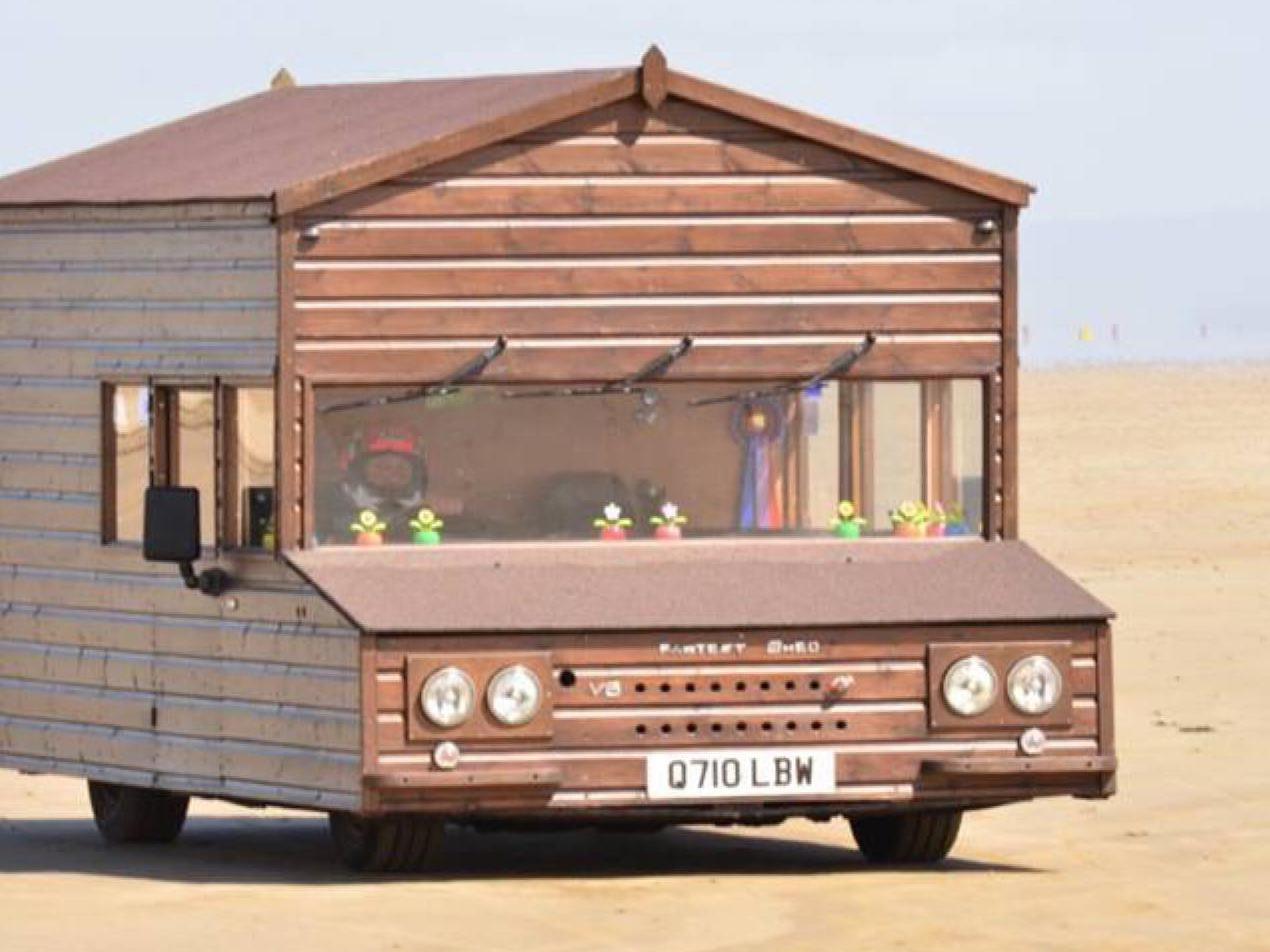 A motorised shed has broken a land speed record after its owner hit 100mph driving along a Welsh beach