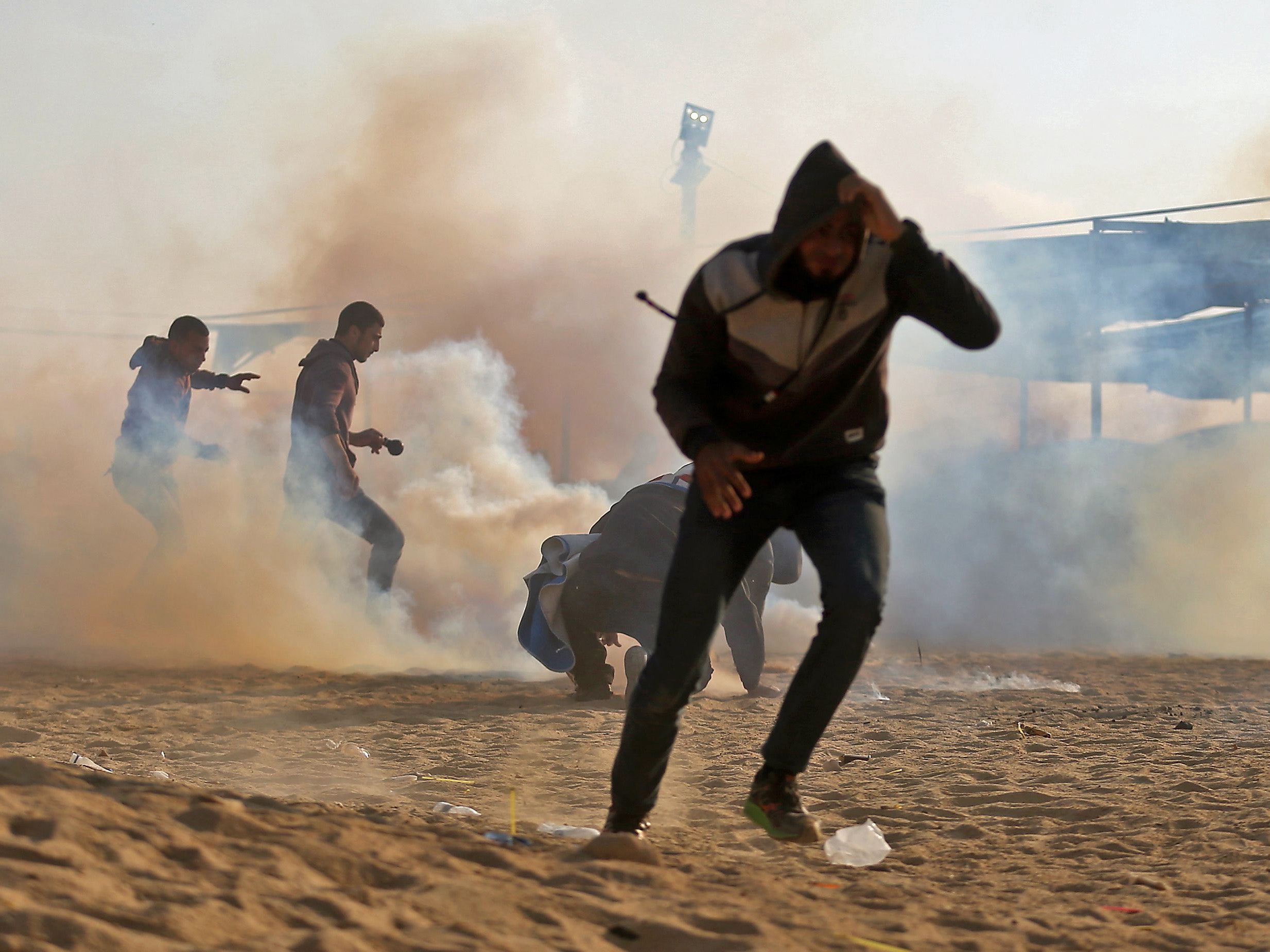 Palestinian protesters flee from tear gas during the demonstrations on Monday