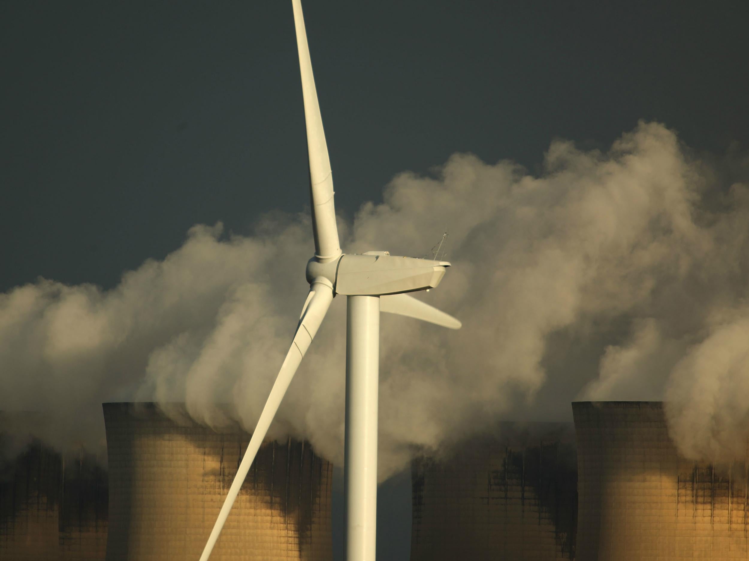 Wind turbines generate electricty in the shadow of Drax, Europe's second biggest coal-fired power station