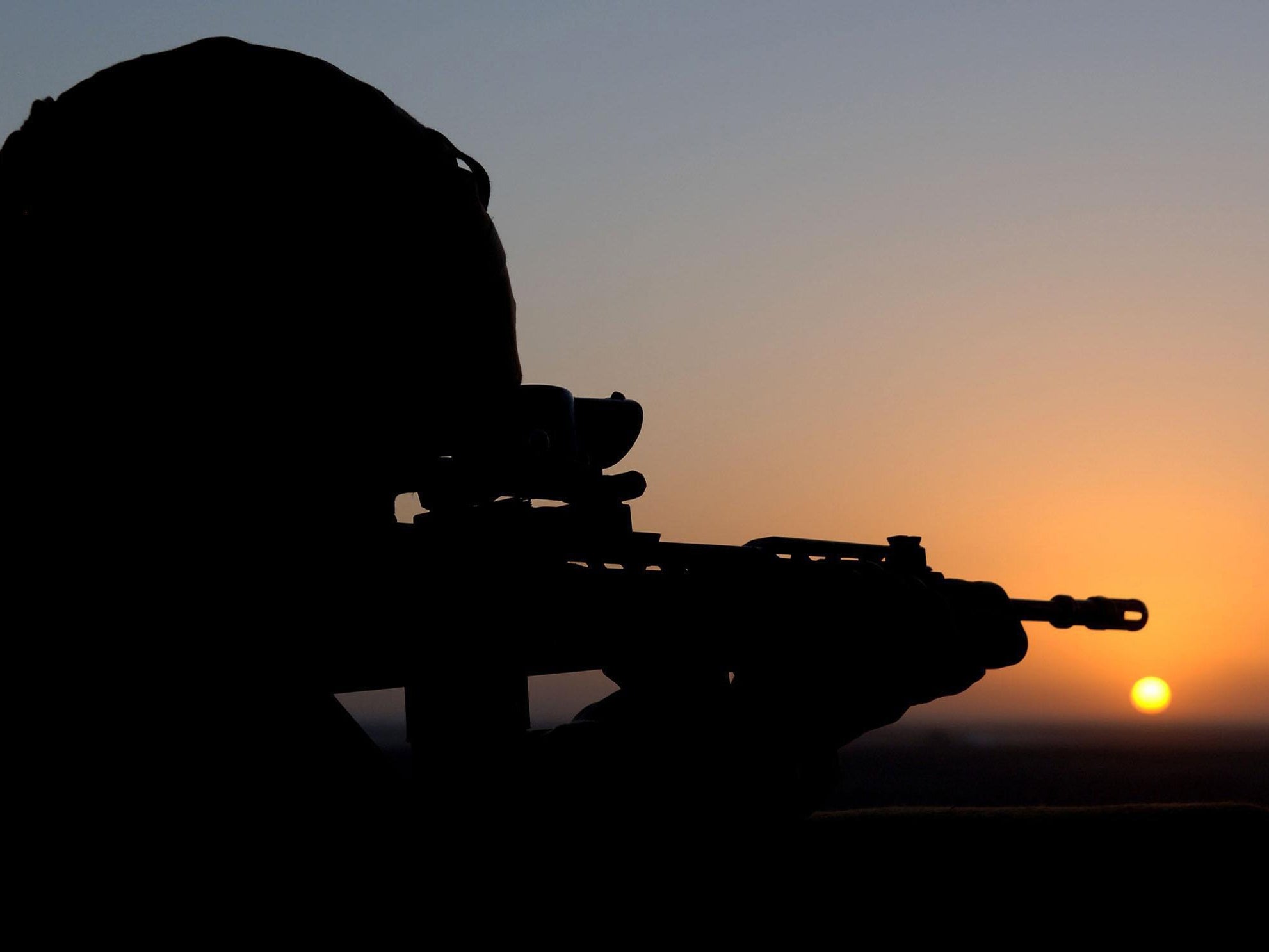 The sun sets as a Royal Marine stands guard in the watchtower at Forward Operating Base Prise near Gereshk in Afghanistan, in 2007