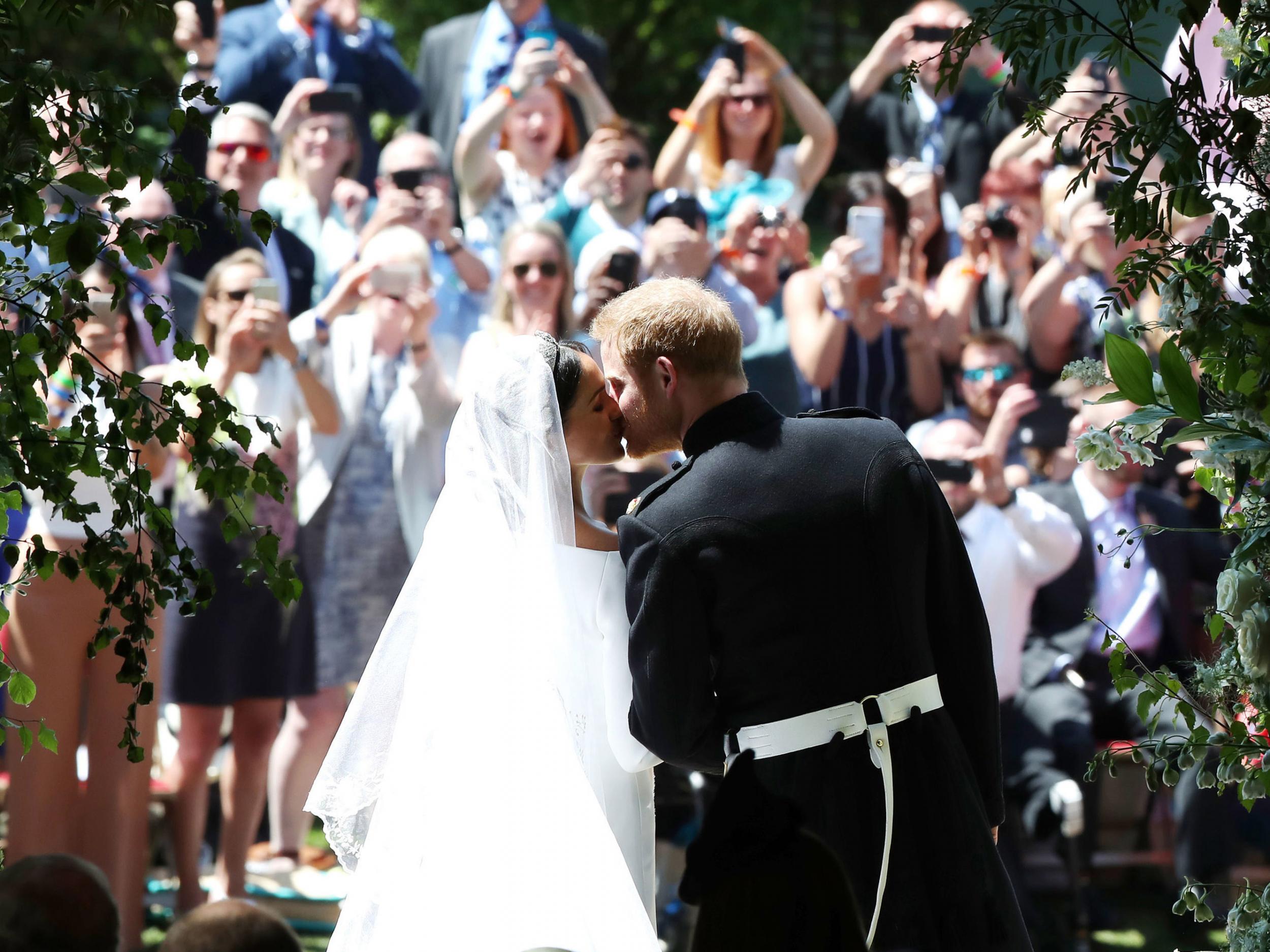 The newlyweds pucker up on the steps of St George’s Chapel