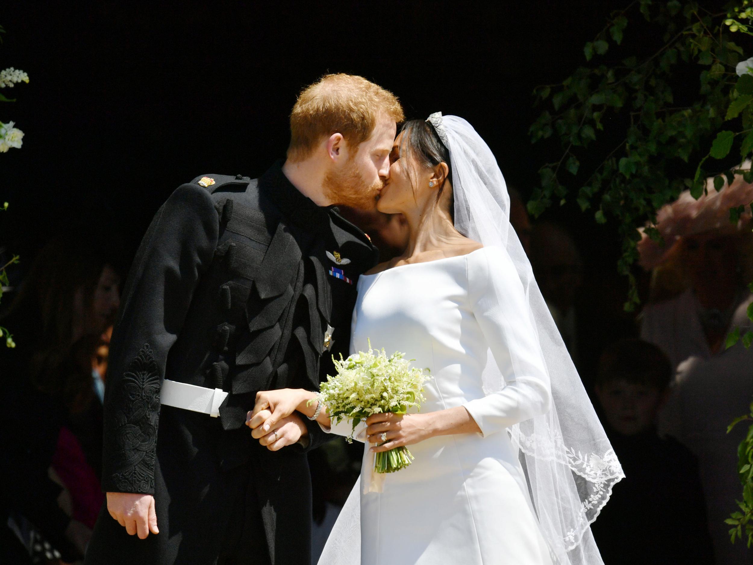 The Duke and Duchess of Sussex kiss on the steps of St George’s Chapel after their wedding