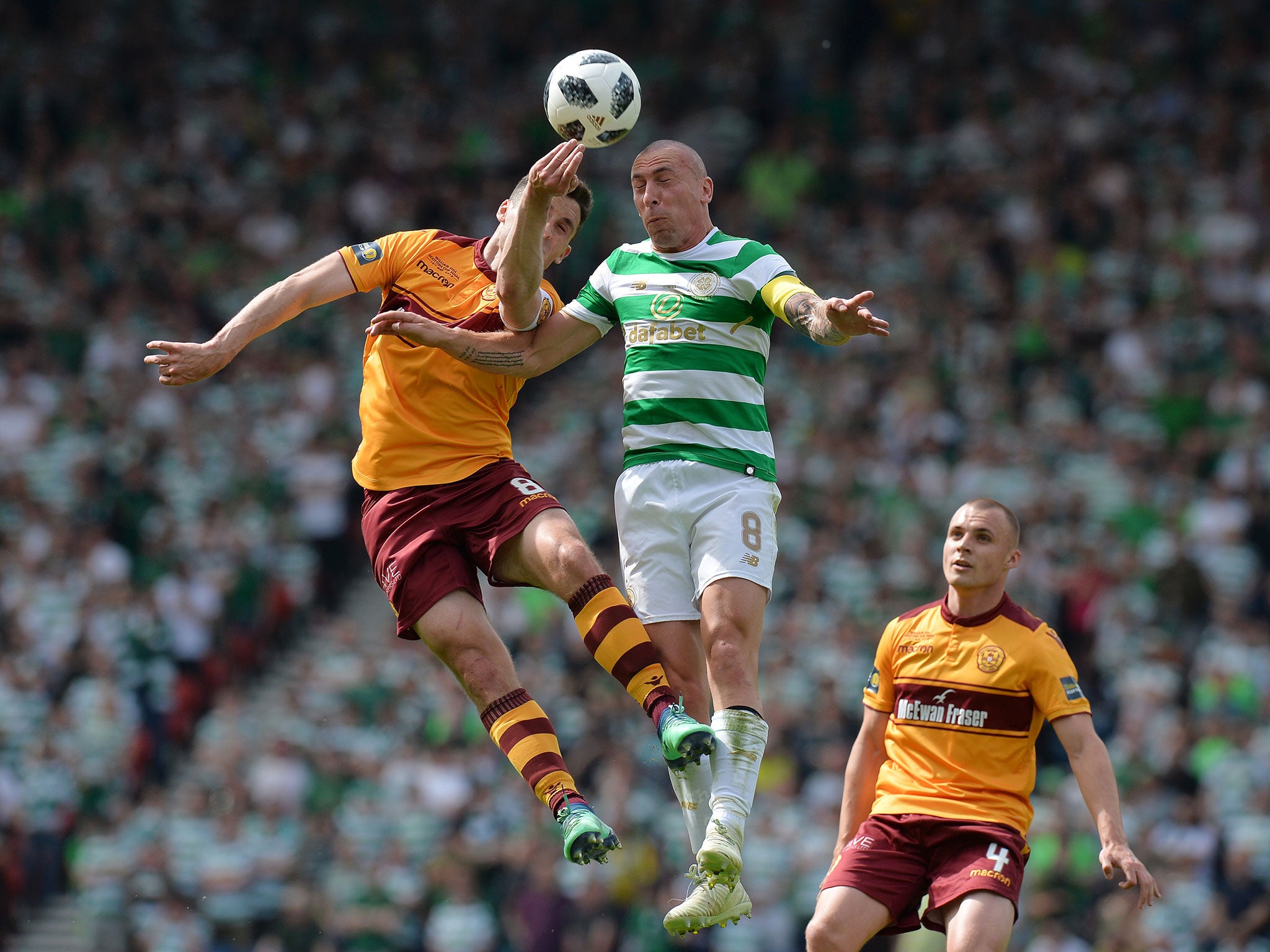 Scott Brown attempts to head clear a Motherwell cross under pressure from Carl McHugh