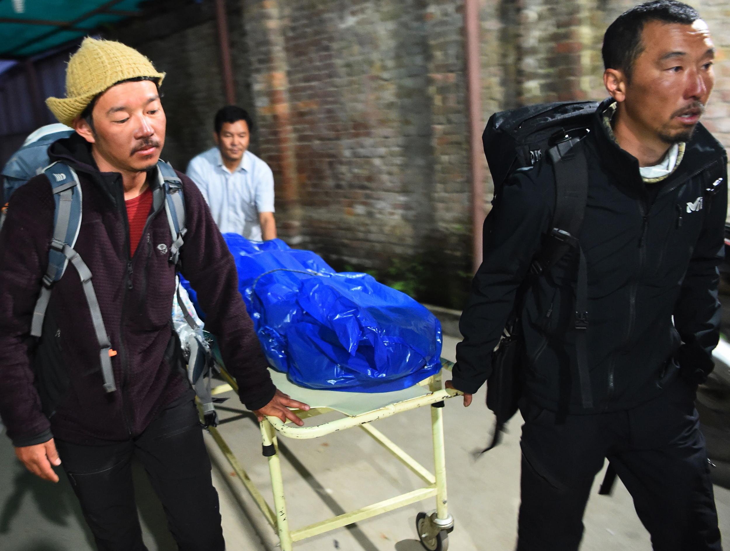 Volunteers and friends carry the body of Japanese climber Nobukazu Kuriki