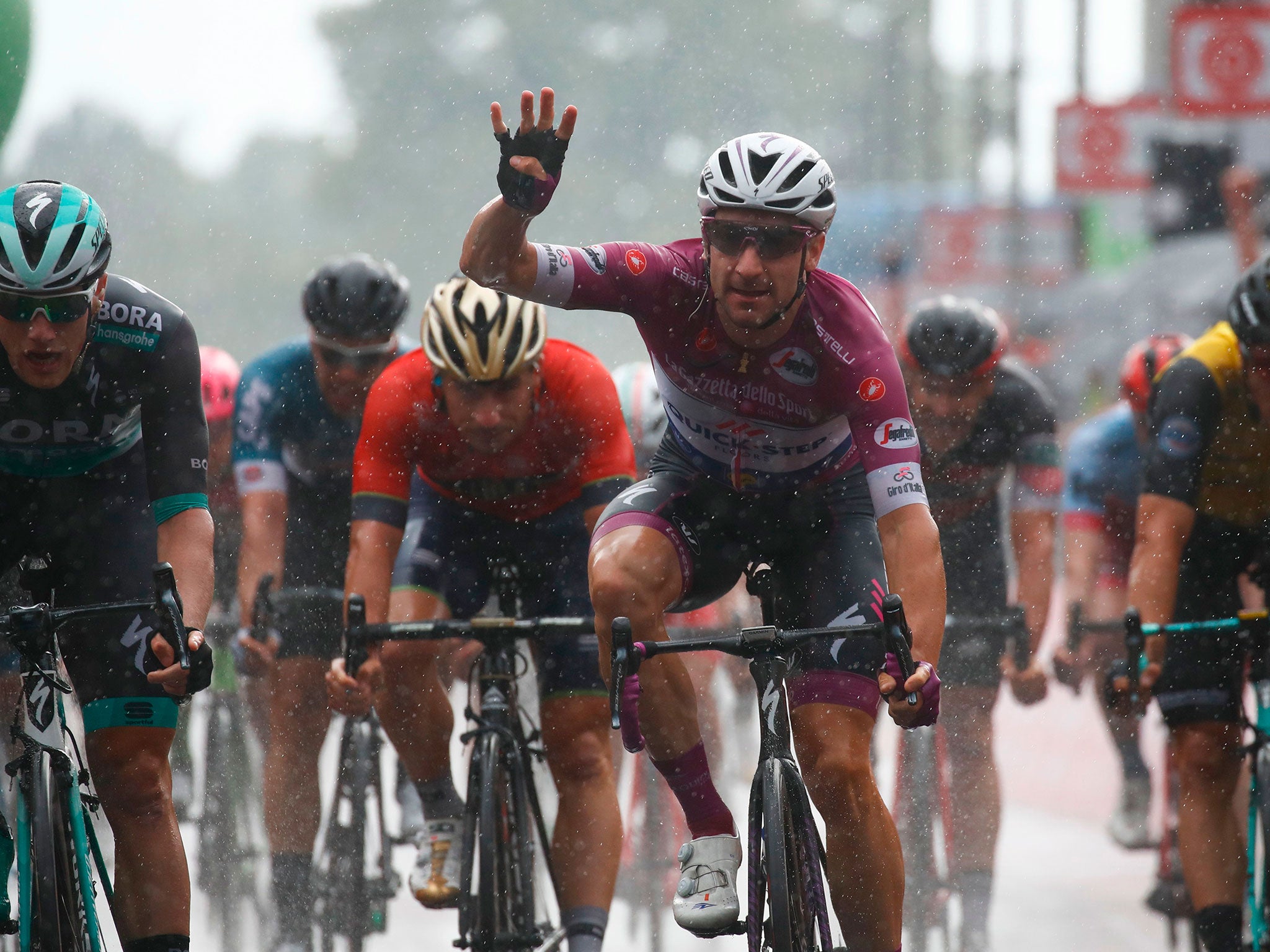 Elia Viviani celebrates as he crosses the finish line to win the 17th stage between Riva del Garda and Iseo