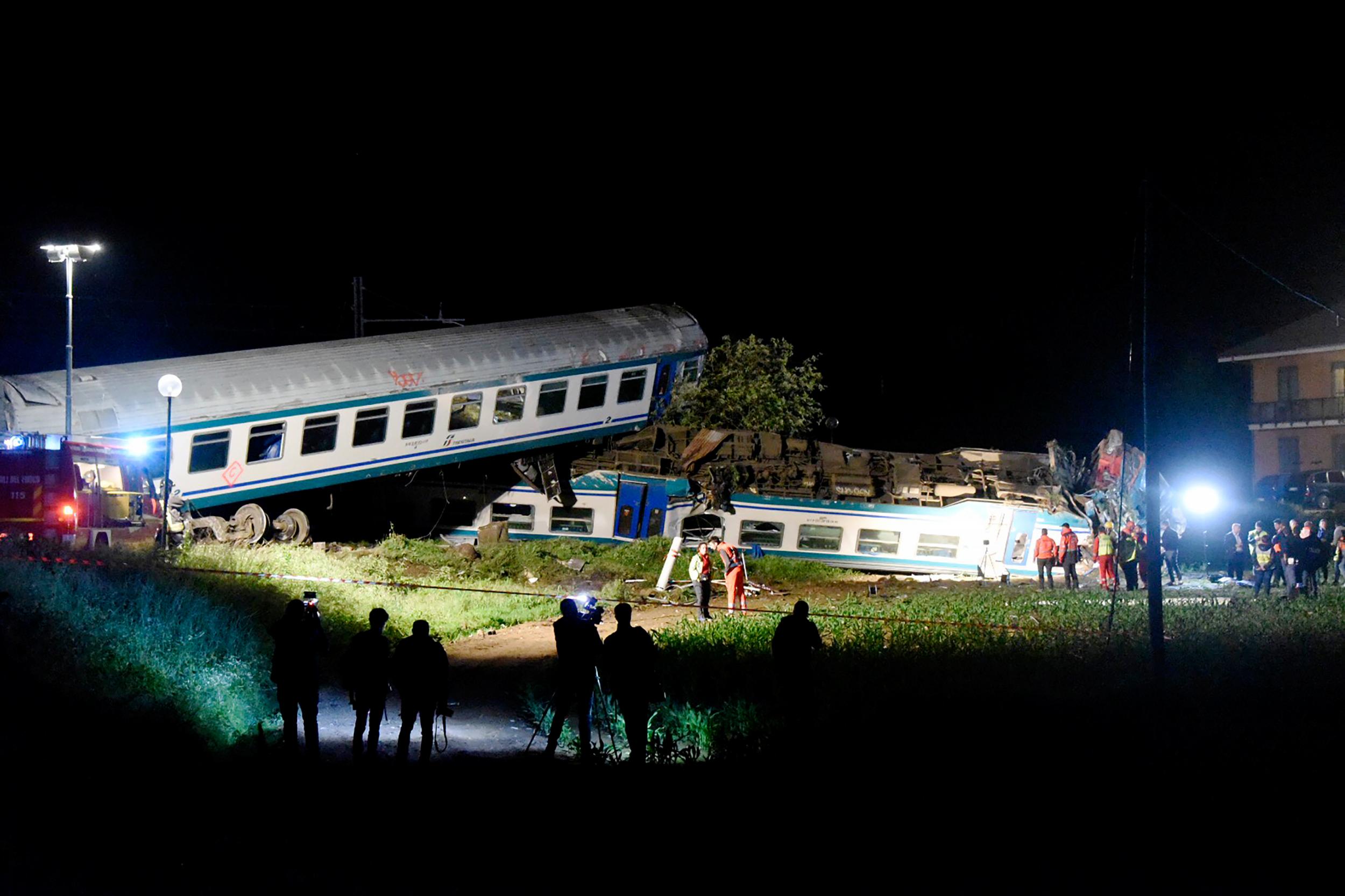 Firefighters and rescue personnel at the site of a crash after a regional train smashed into a truck in Caluso, outside Turin