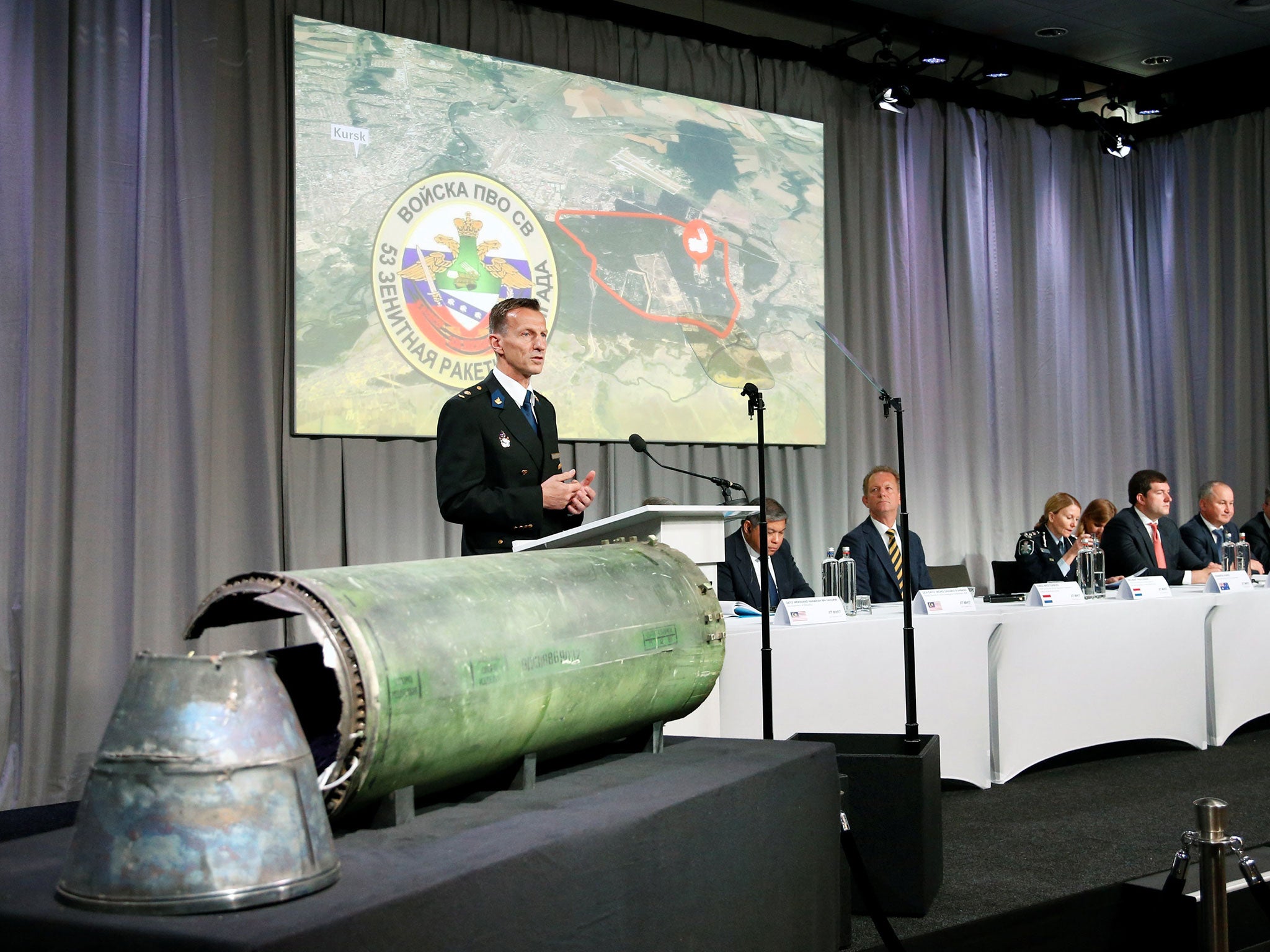 Wilbert Paulissen, head of the Dutch National Crime Squad, stands next to a damaged missile as he presents interim results in the ongoing investigation into the shooting down of MH17