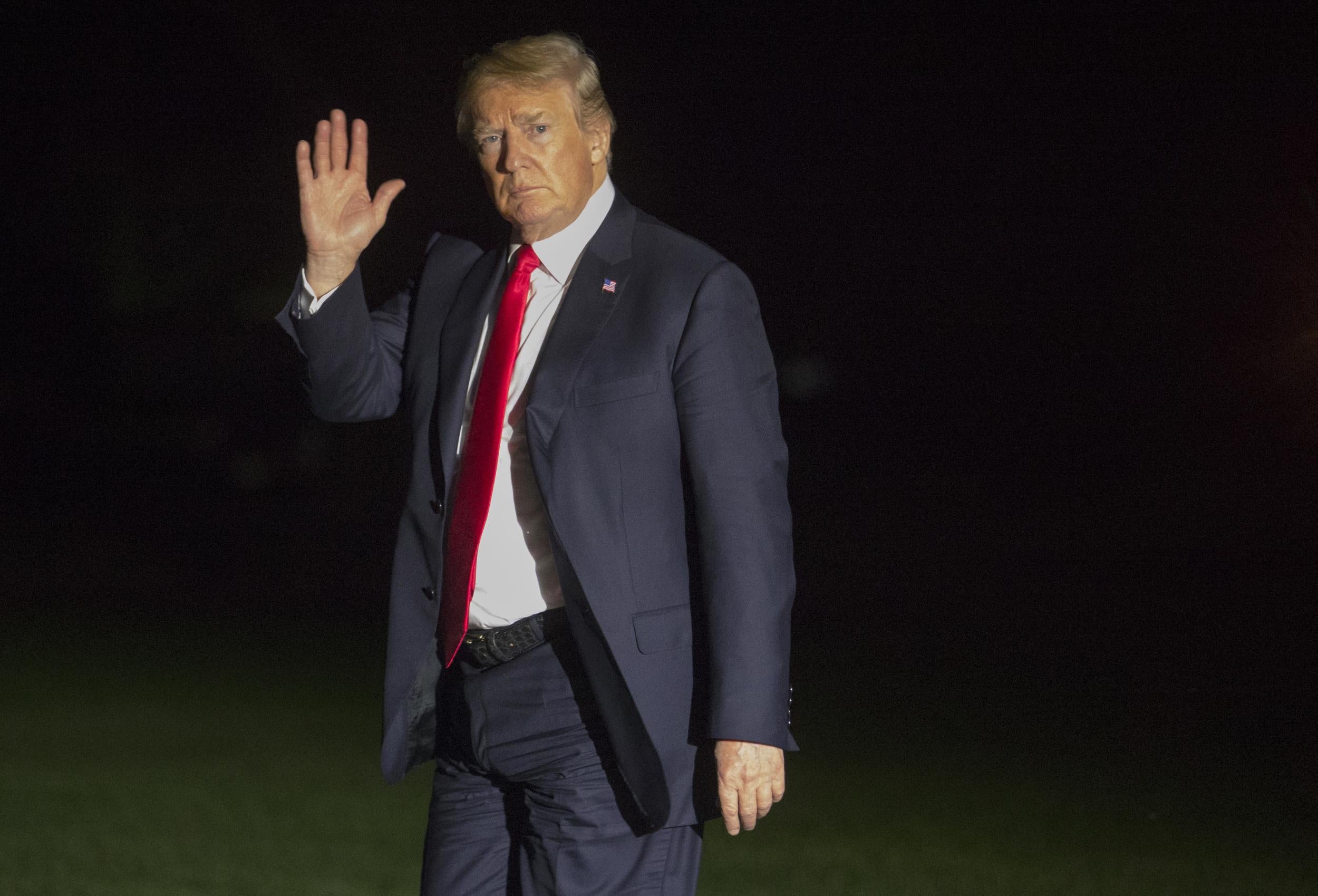 President Donald Trump waves as he walks from the Marine One helicopter as he arrives on the South Lawn of the White House